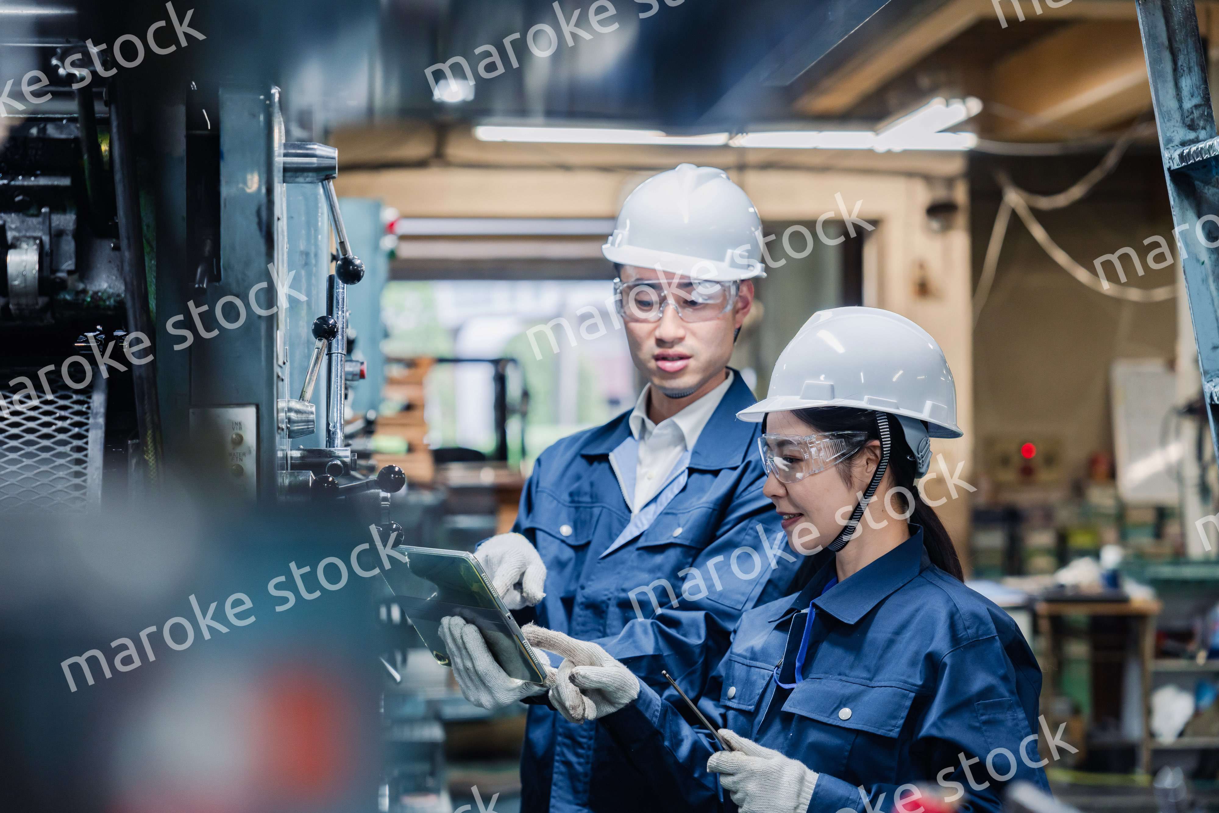 タブレット端末を確認しながら働く技術スタッフ