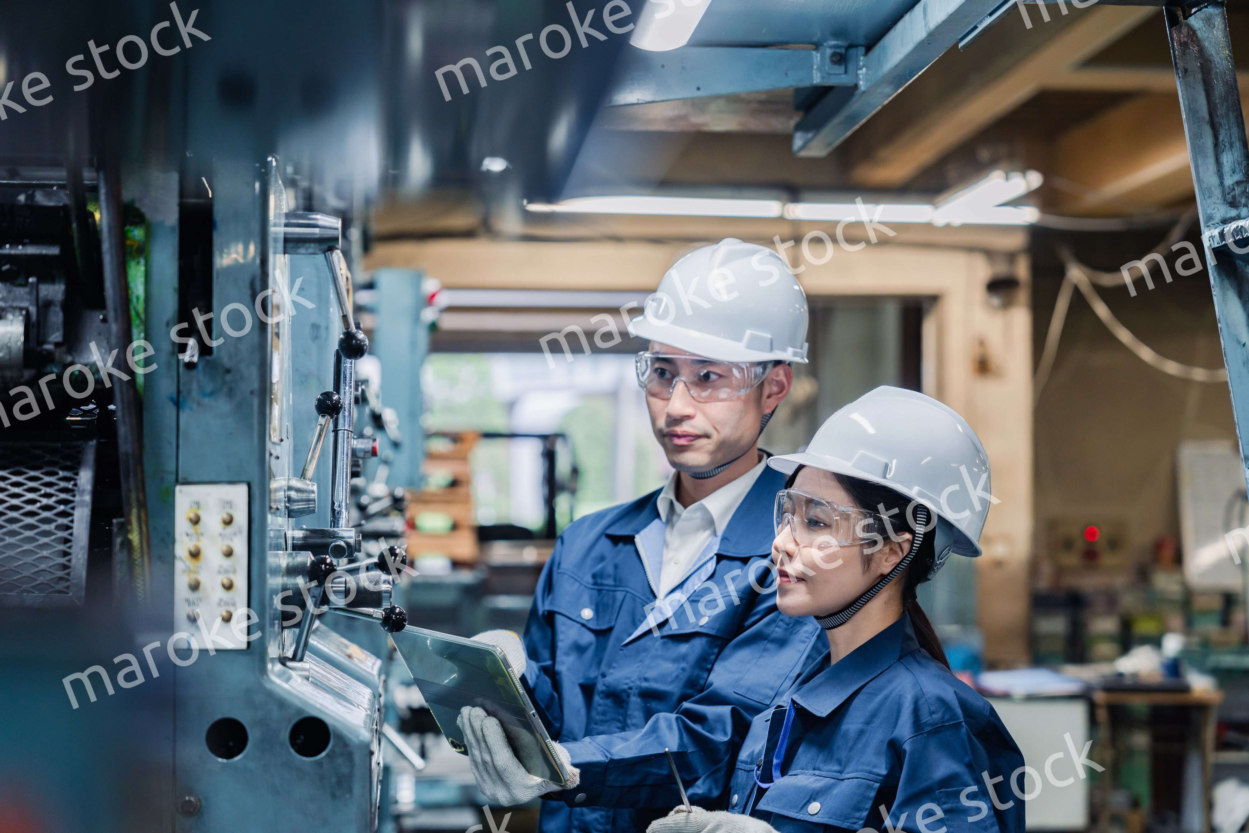 タブレット端末を確認しながら働く技術スタッフ