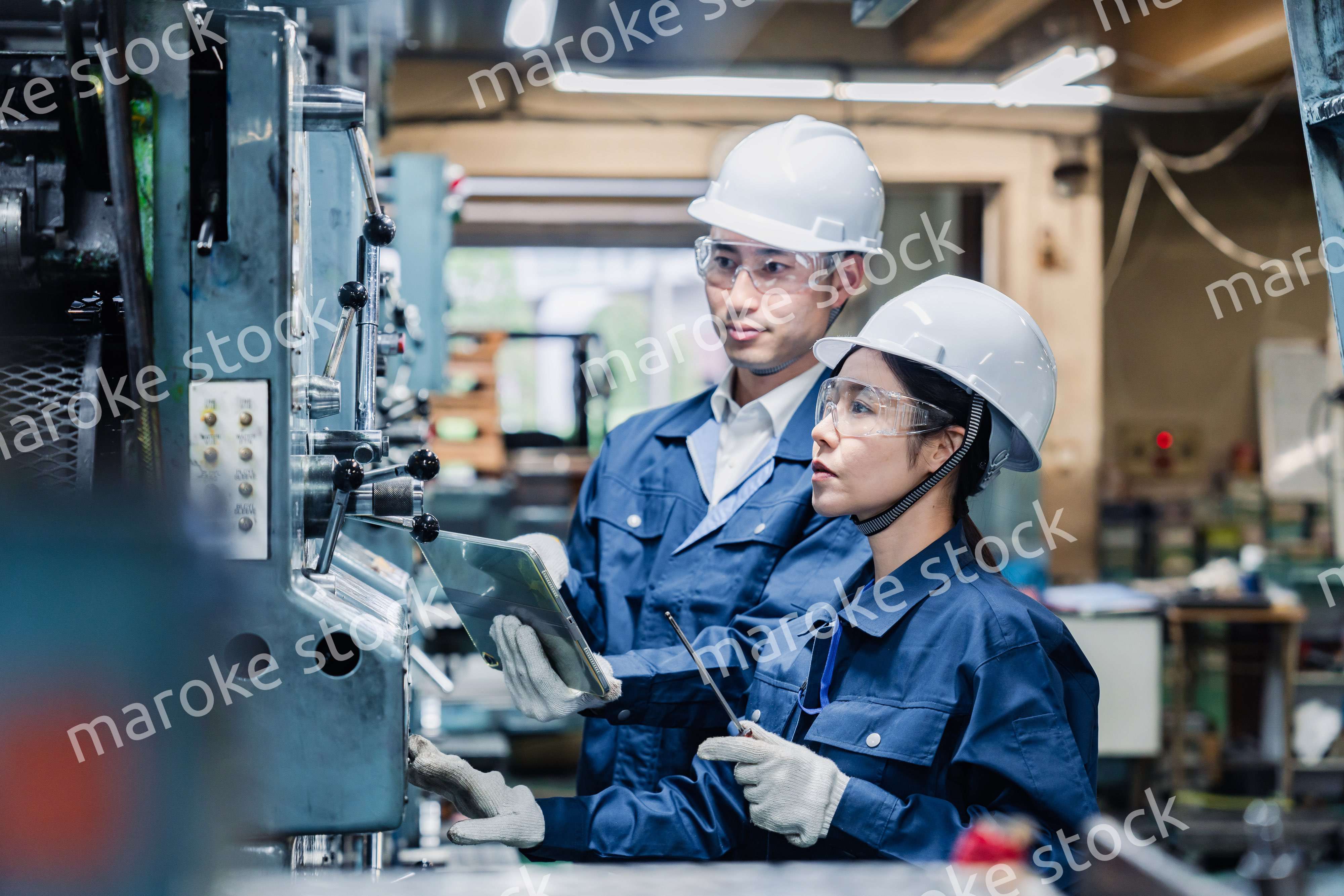 タブレット端末を確認しながら働く技術スタッフ