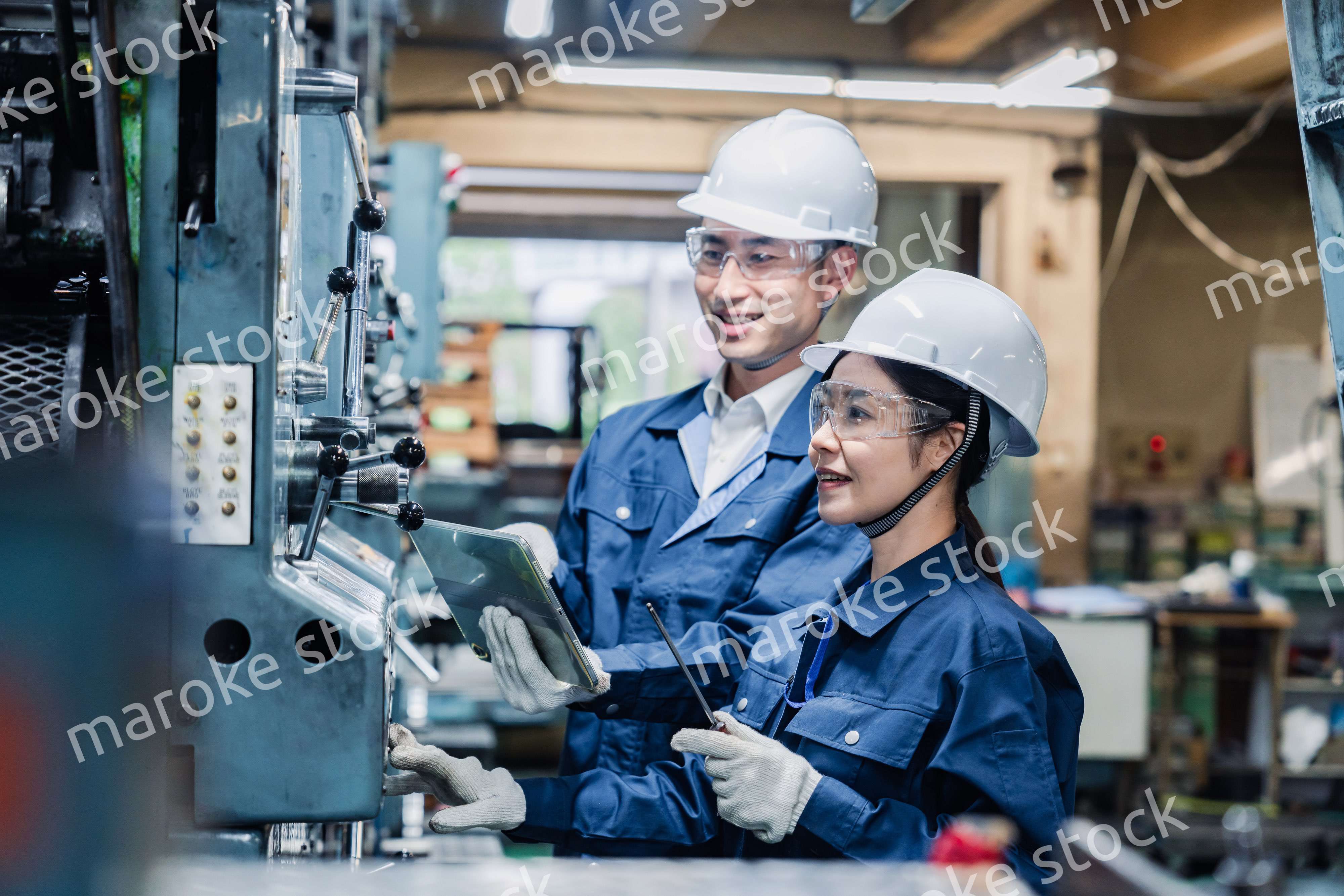 タブレット端末を確認しながら働く技術スタッフ