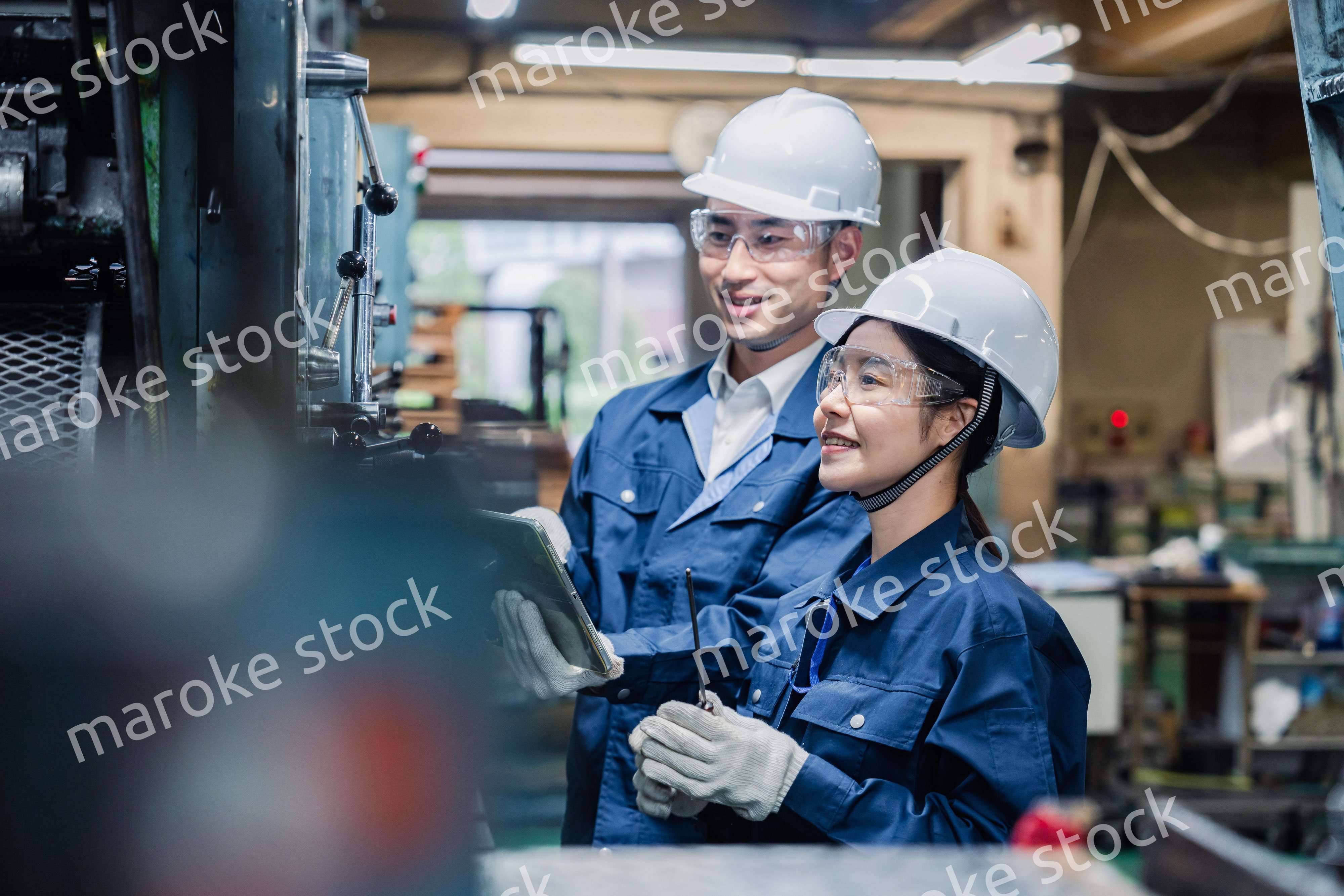 タブレット端末を確認しながら働く技術スタッフ