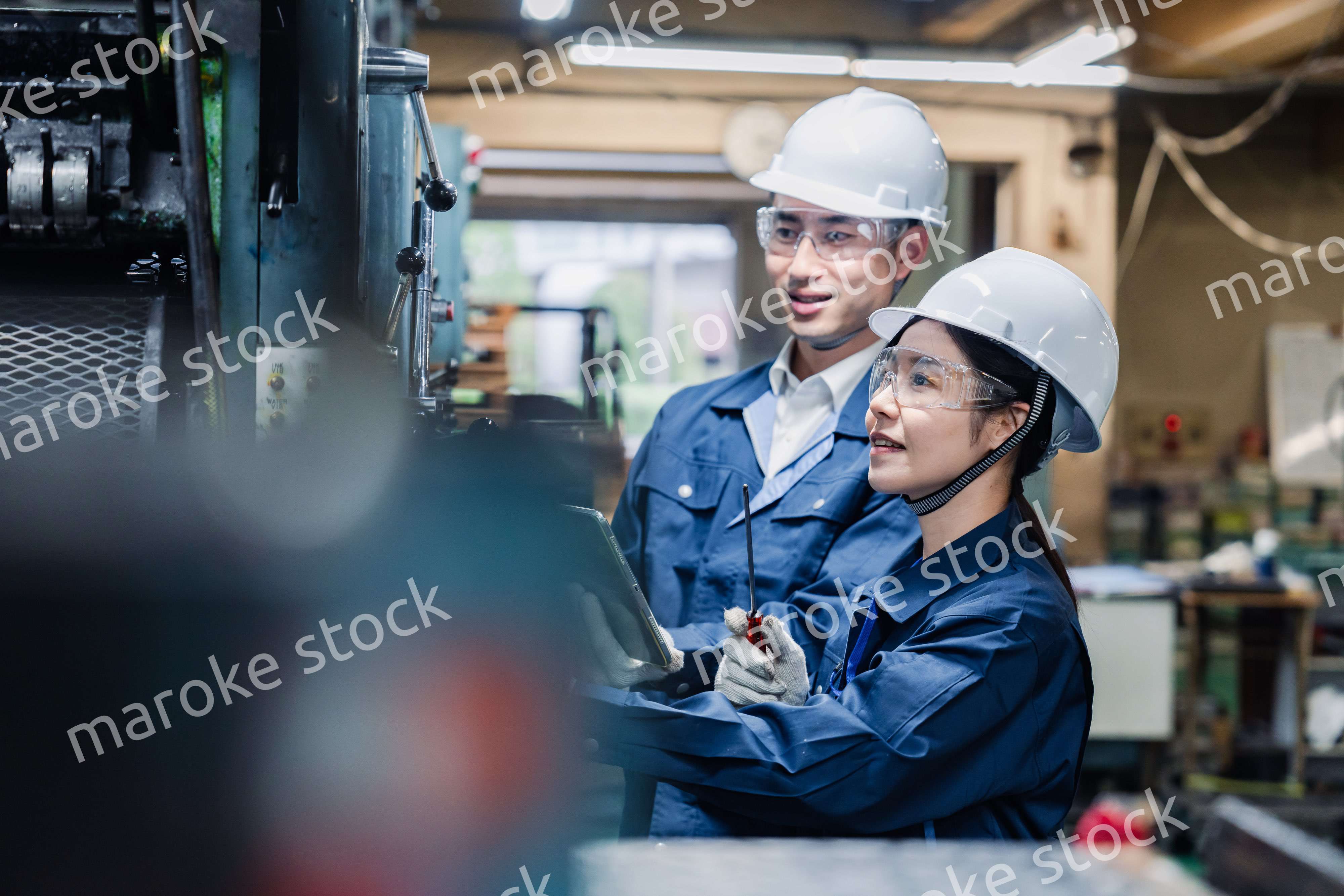 タブレット端末を確認しながら働く技術スタッフ