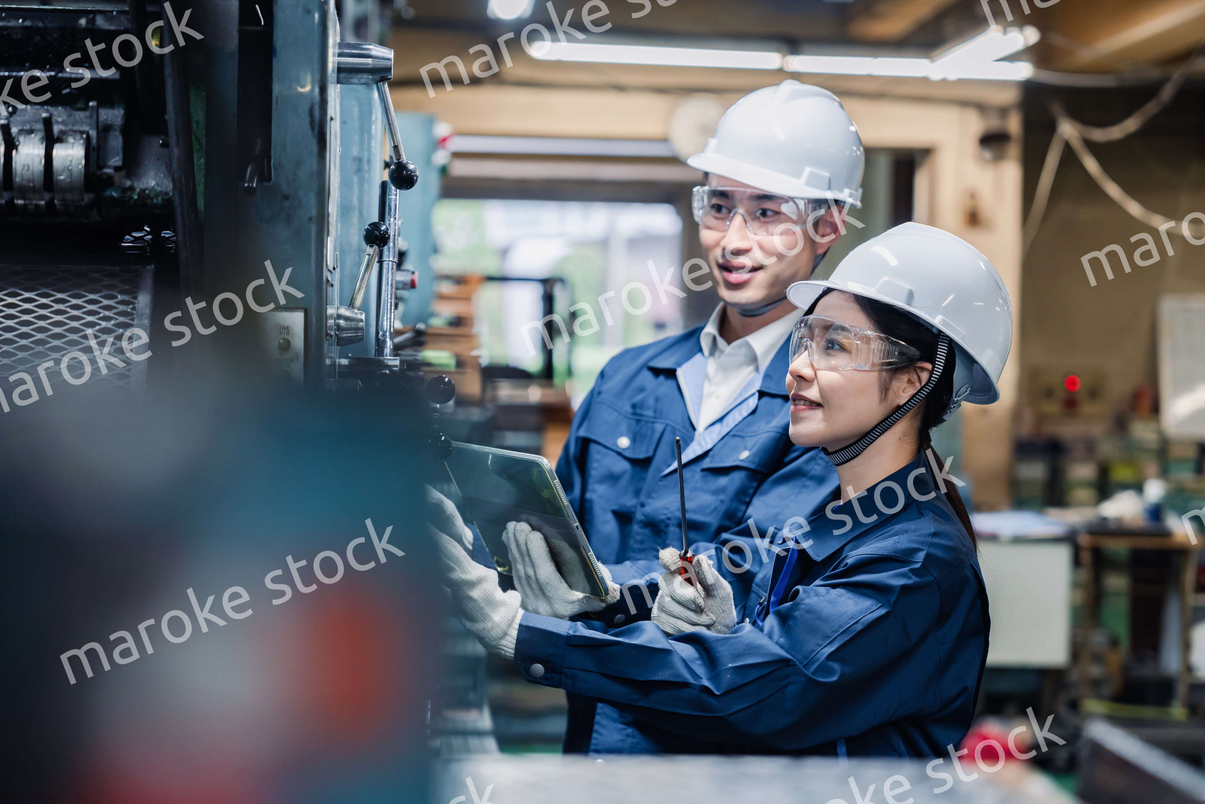 タブレット端末を確認しながら働く技術スタッフ