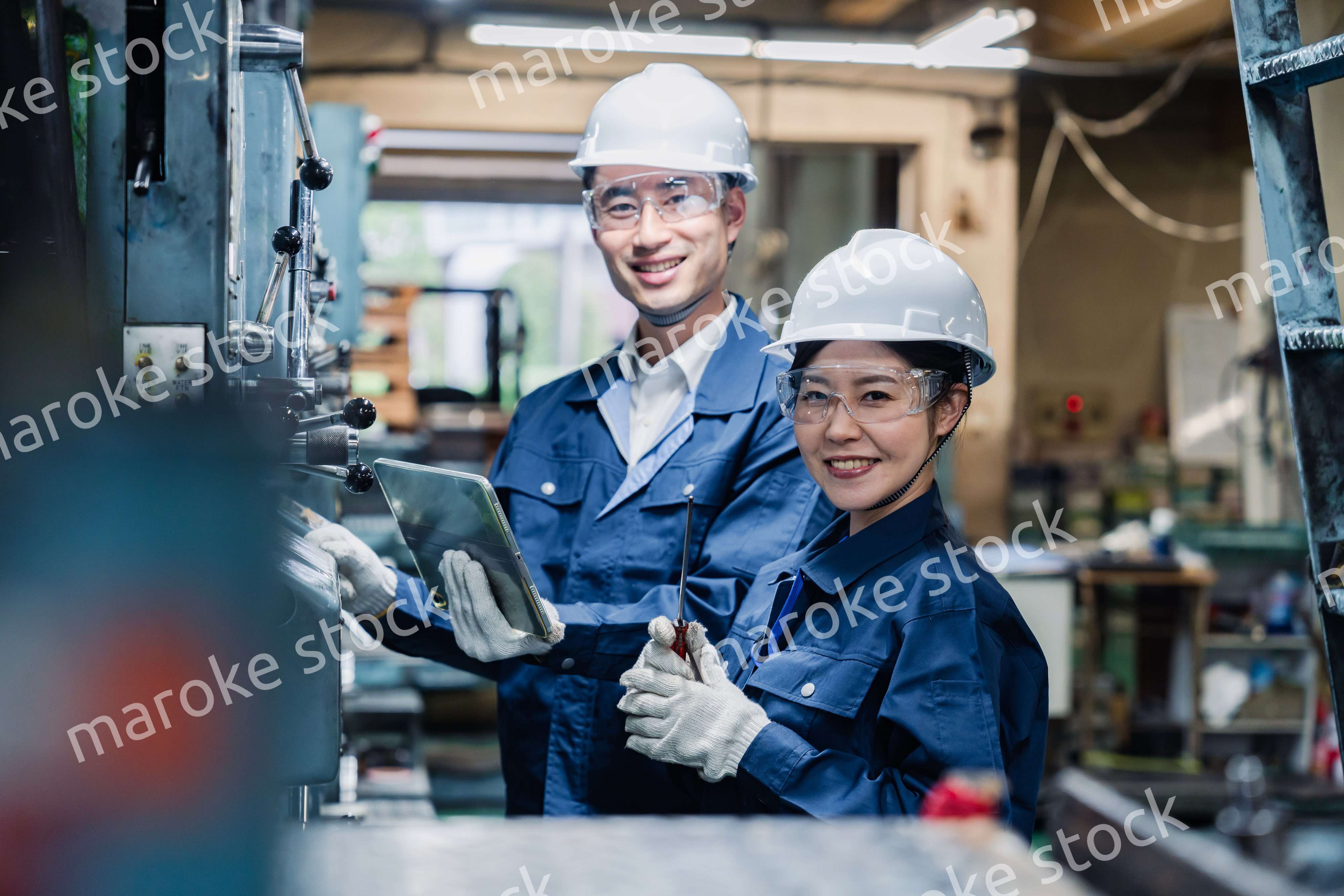 タブレット端末を確認しながら働く技術スタッフ