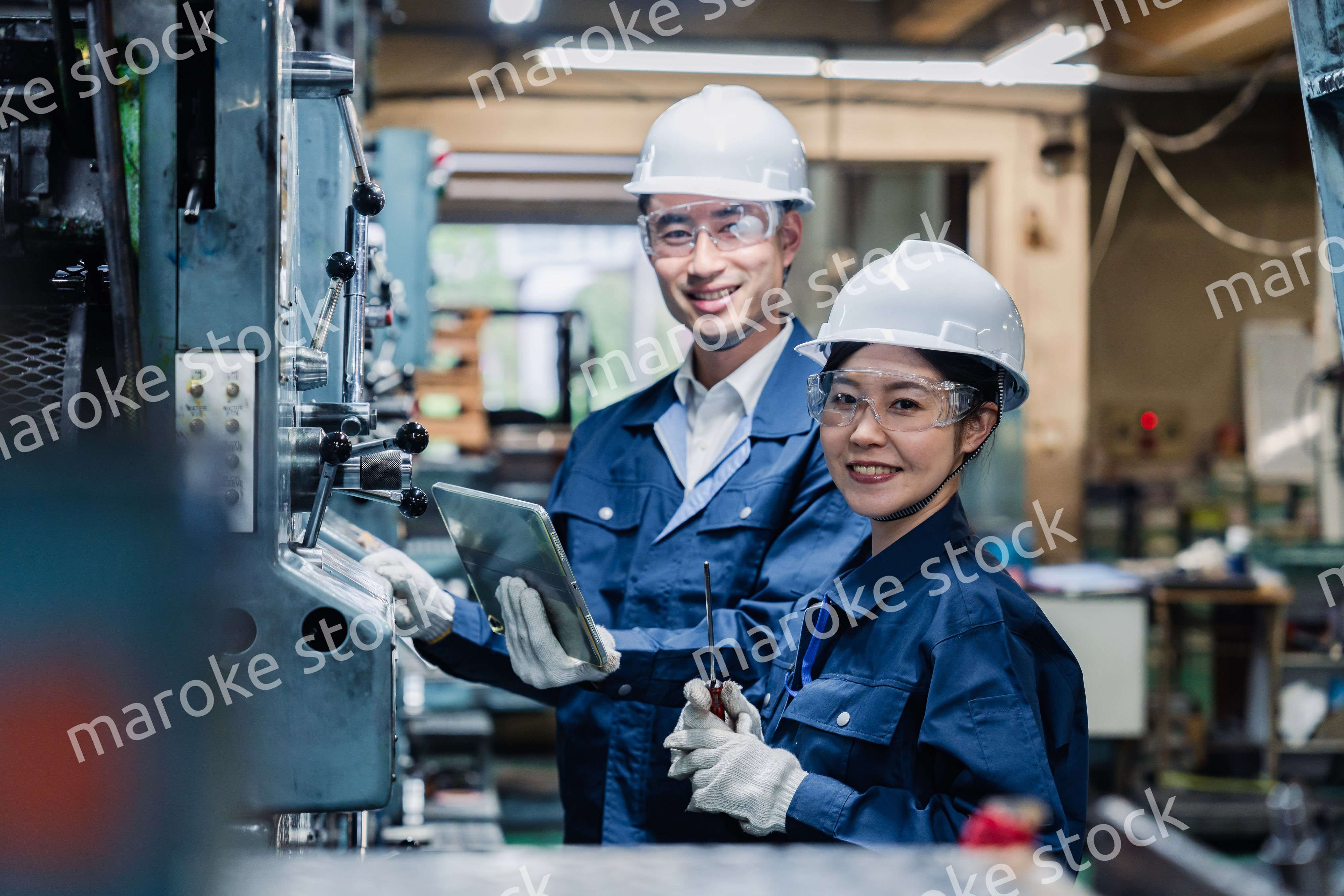 タブレット端末を確認しながら働く技術スタッフ