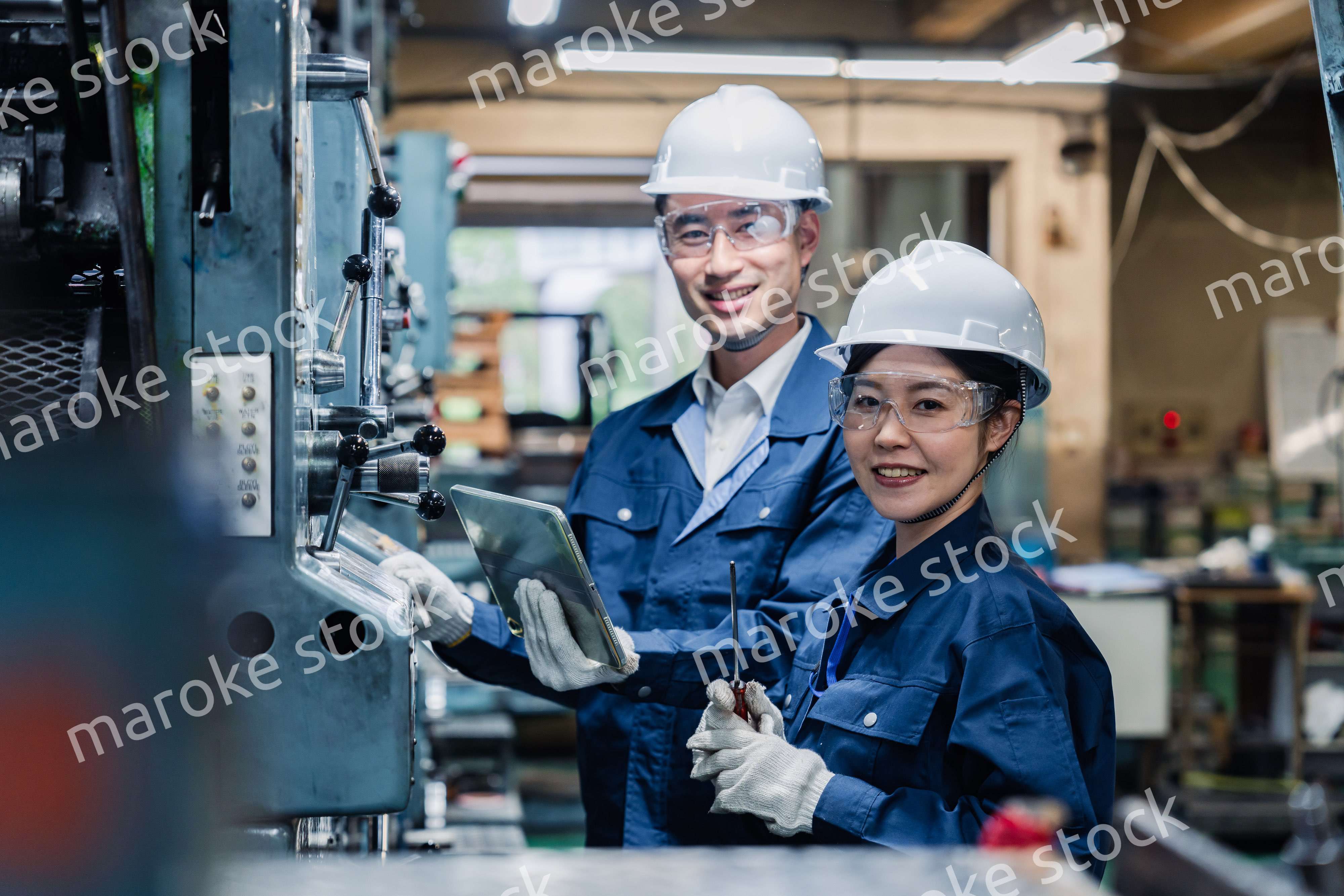 タブレット端末を確認しながら働く技術スタッフ