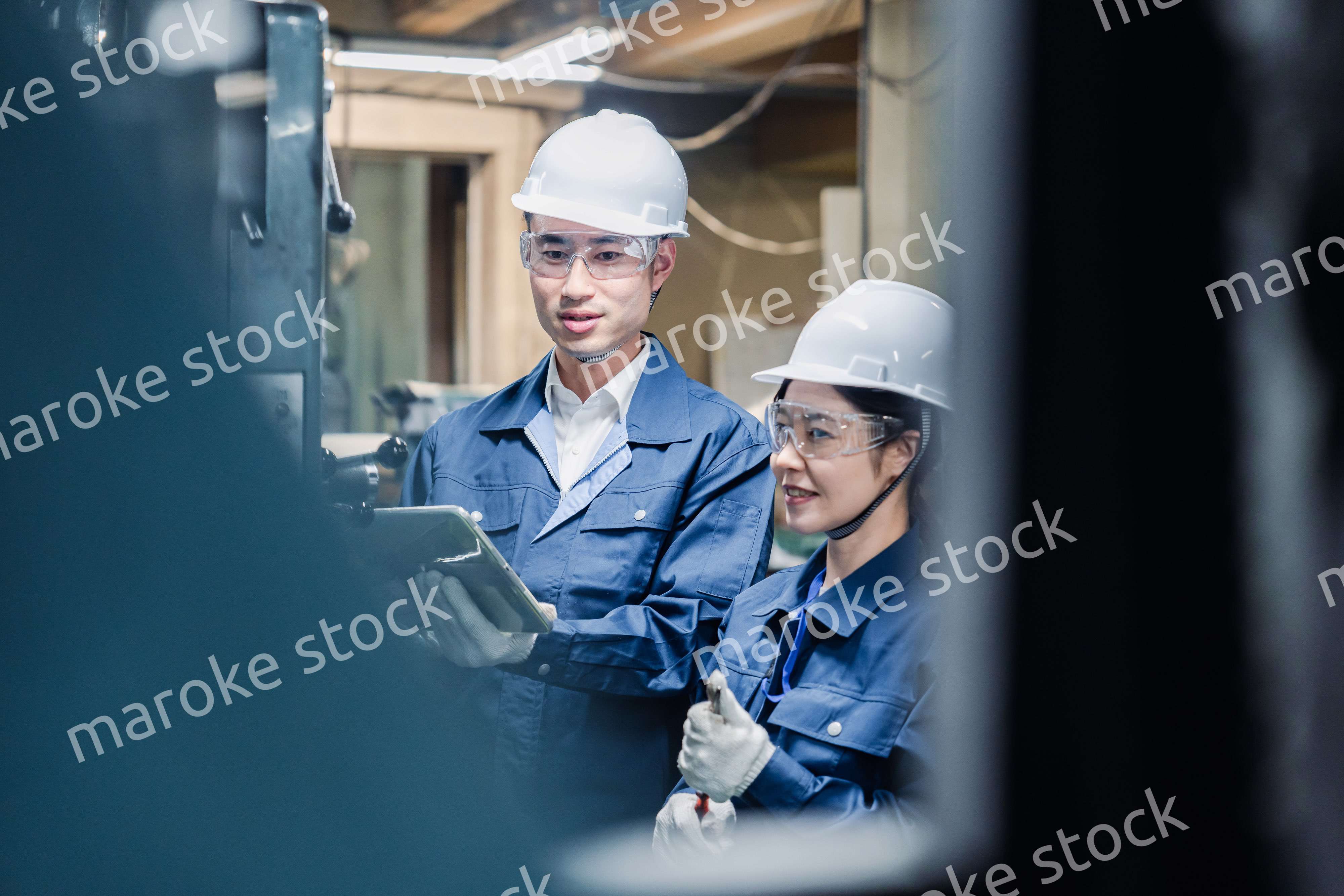 タブレット端末を確認しながら働く技術スタッフ