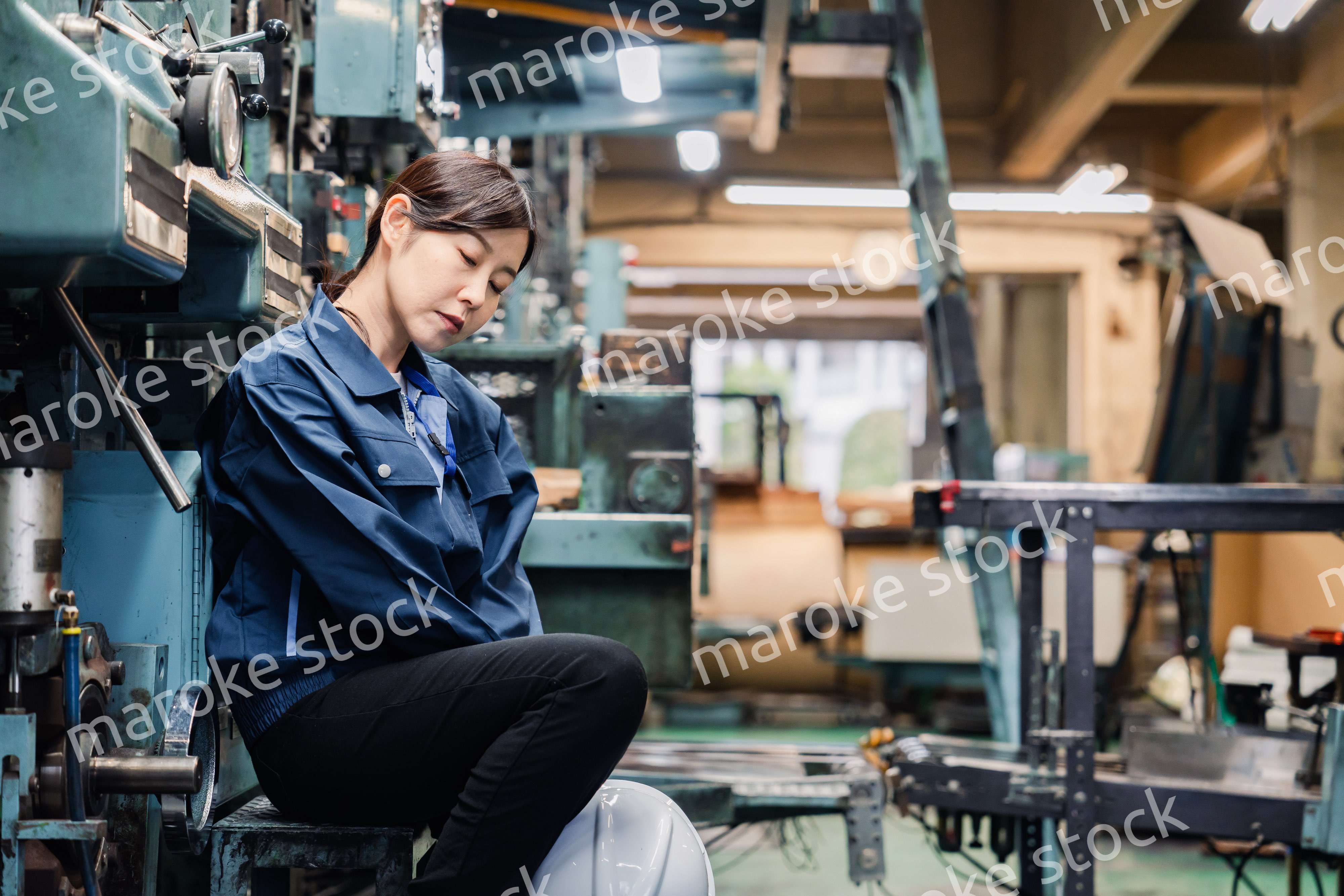 過労でやる気をなくす工場労働者の女性