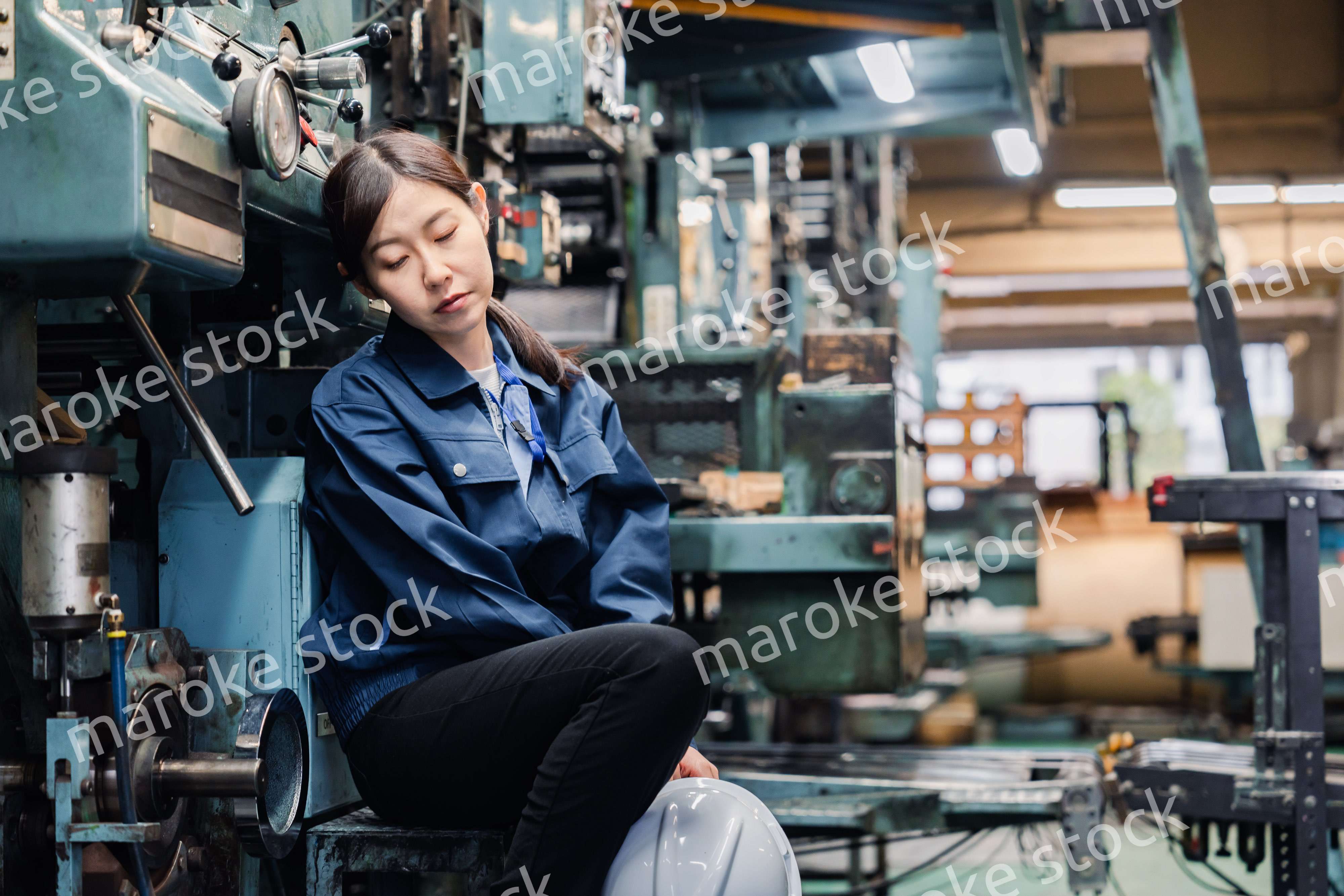 過労でやる気をなくす工場労働者の女性