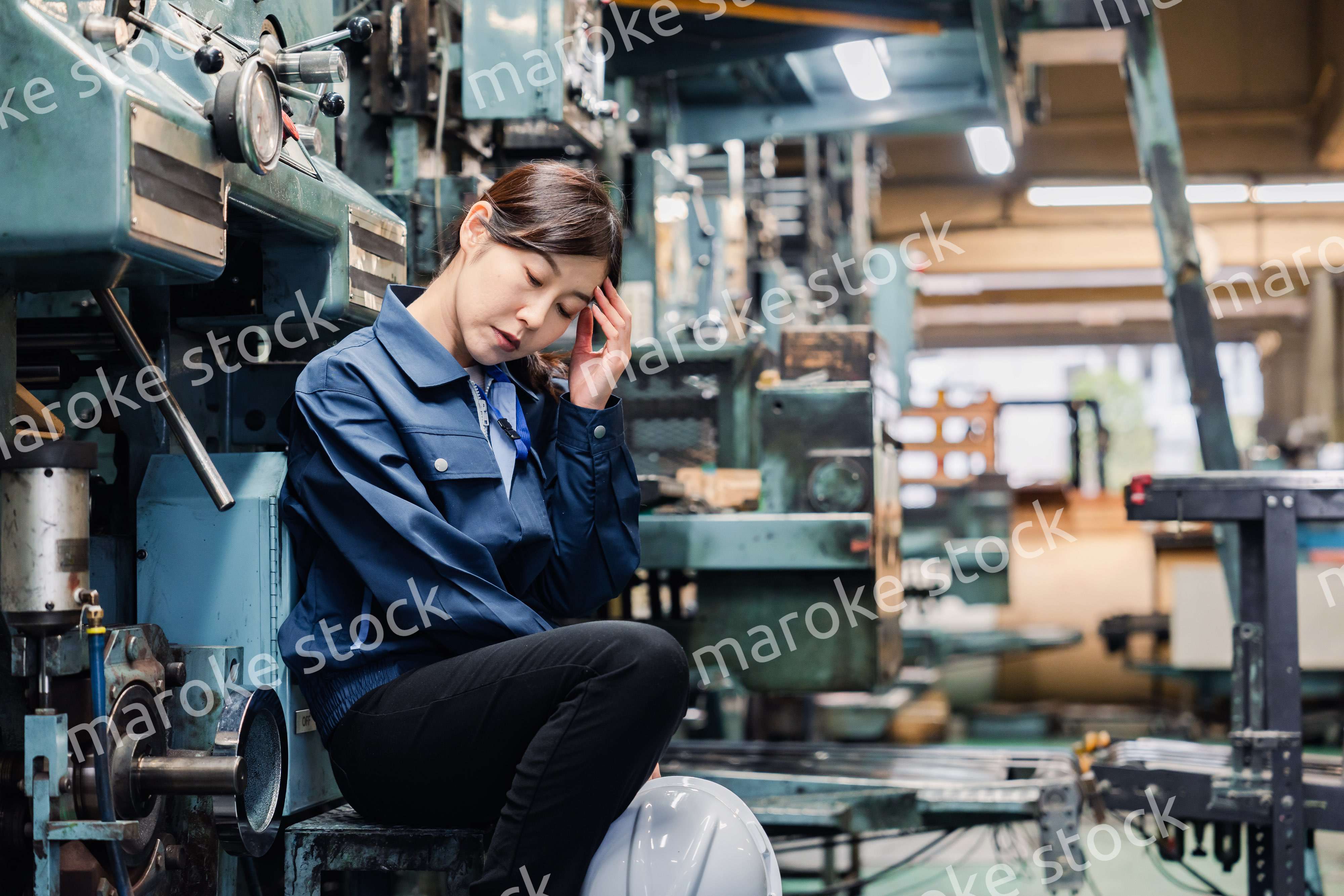 過労でやる気をなくす工場労働者の女性