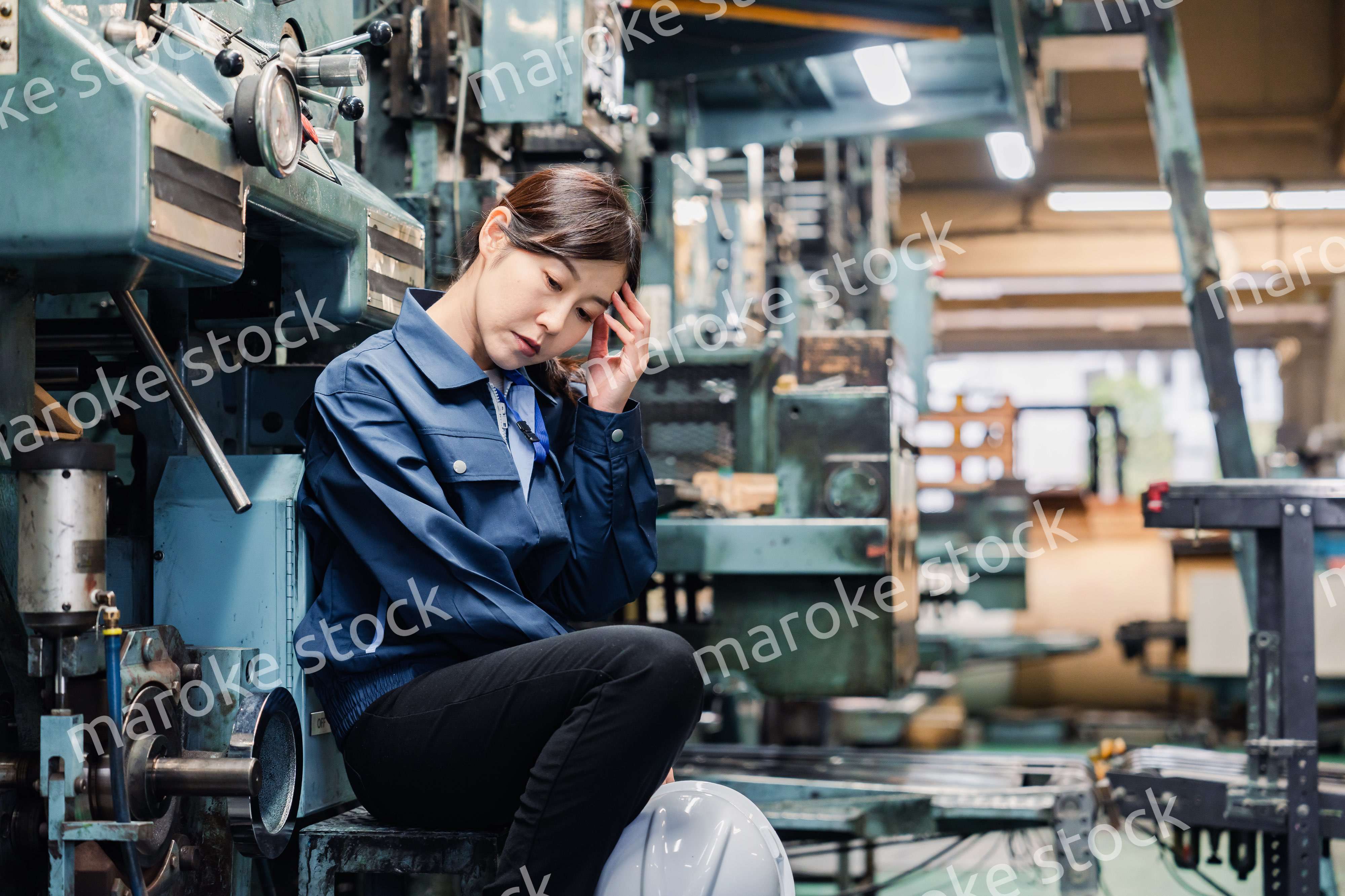 過労でやる気をなくす工場労働者の女性