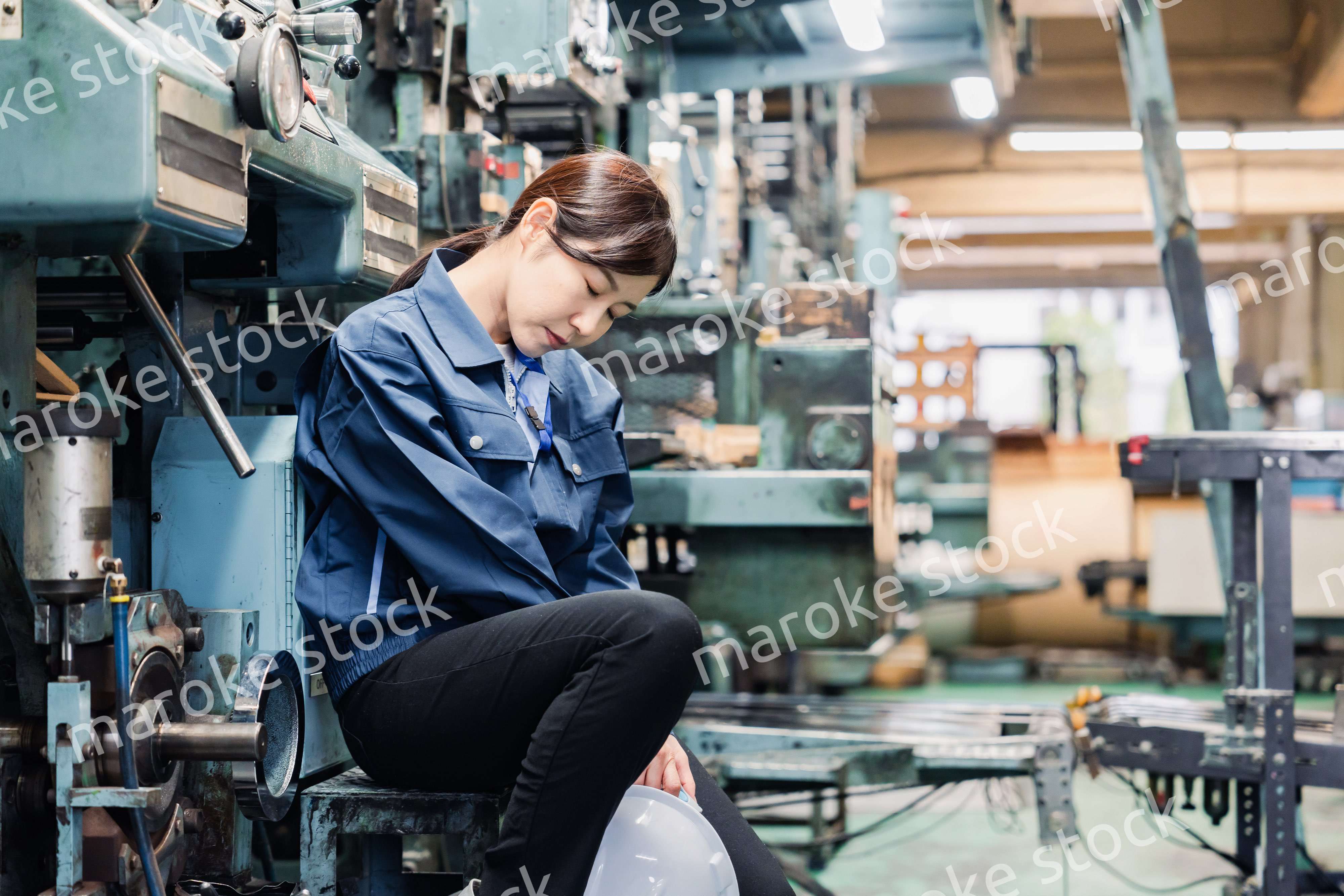 過労でやる気をなくす工場労働者の女性