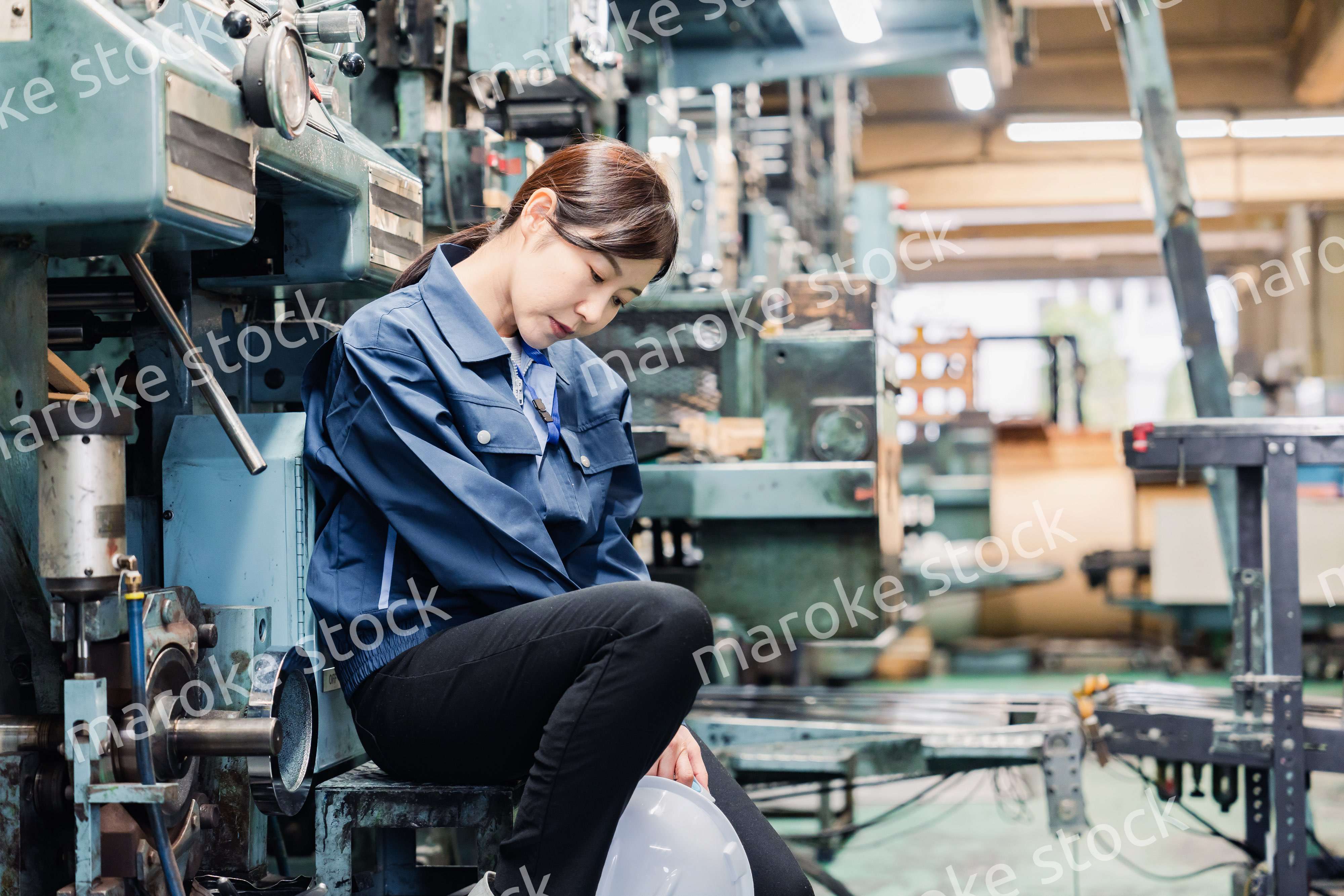 過労でやる気をなくす工場労働者の女性