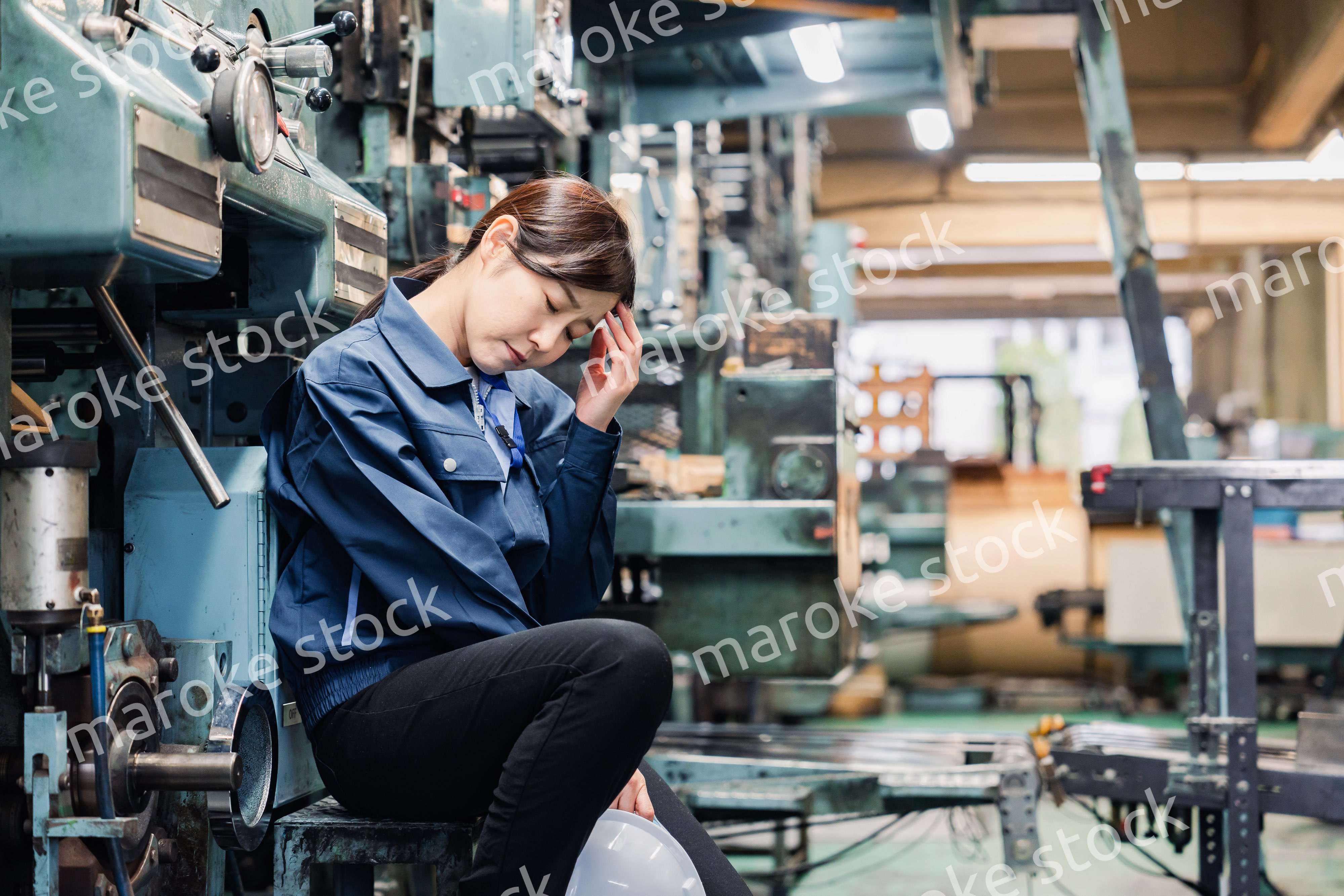 過労でやる気をなくす工場労働者の女性