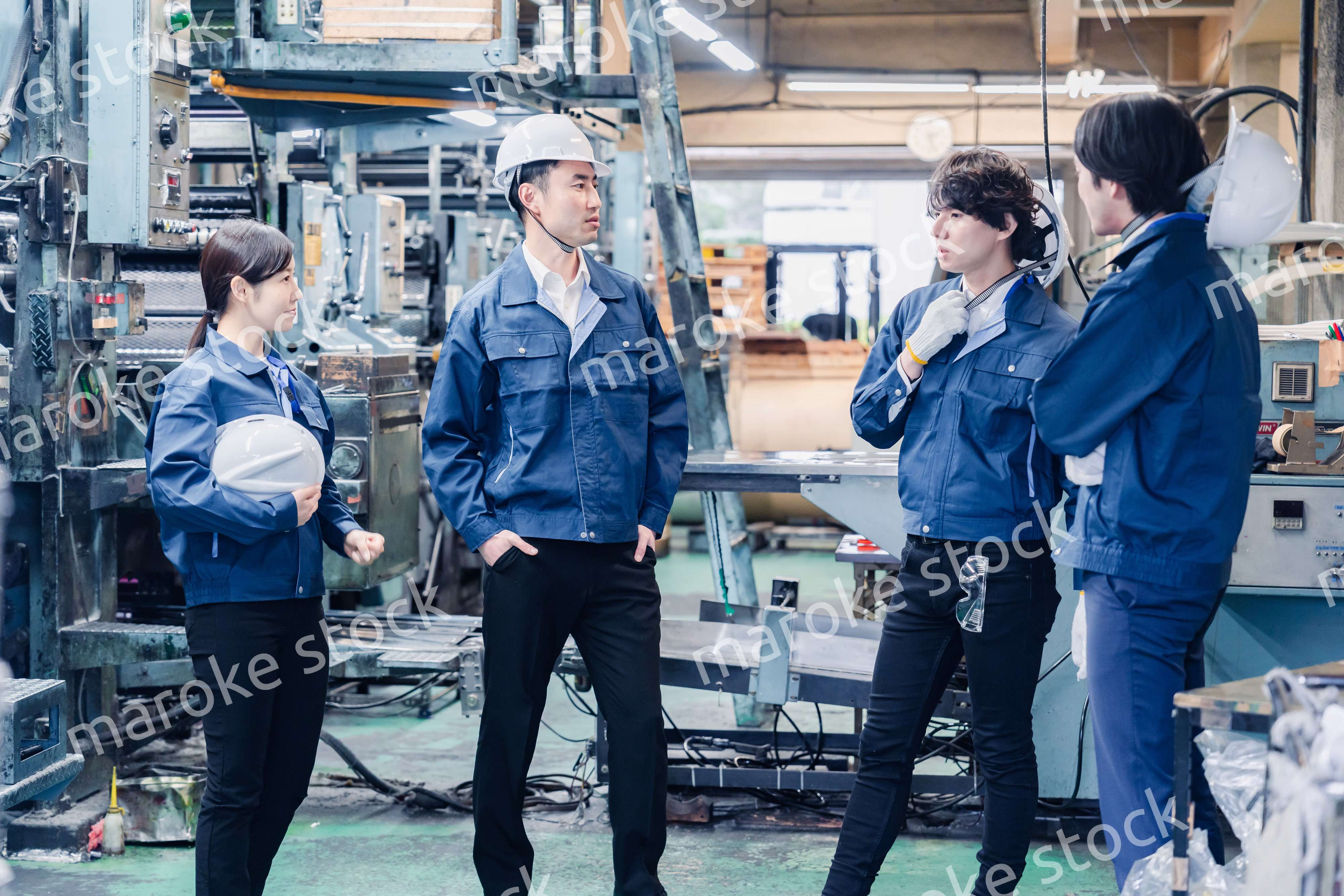 休憩時間に仲良く雑談をする工場労働者