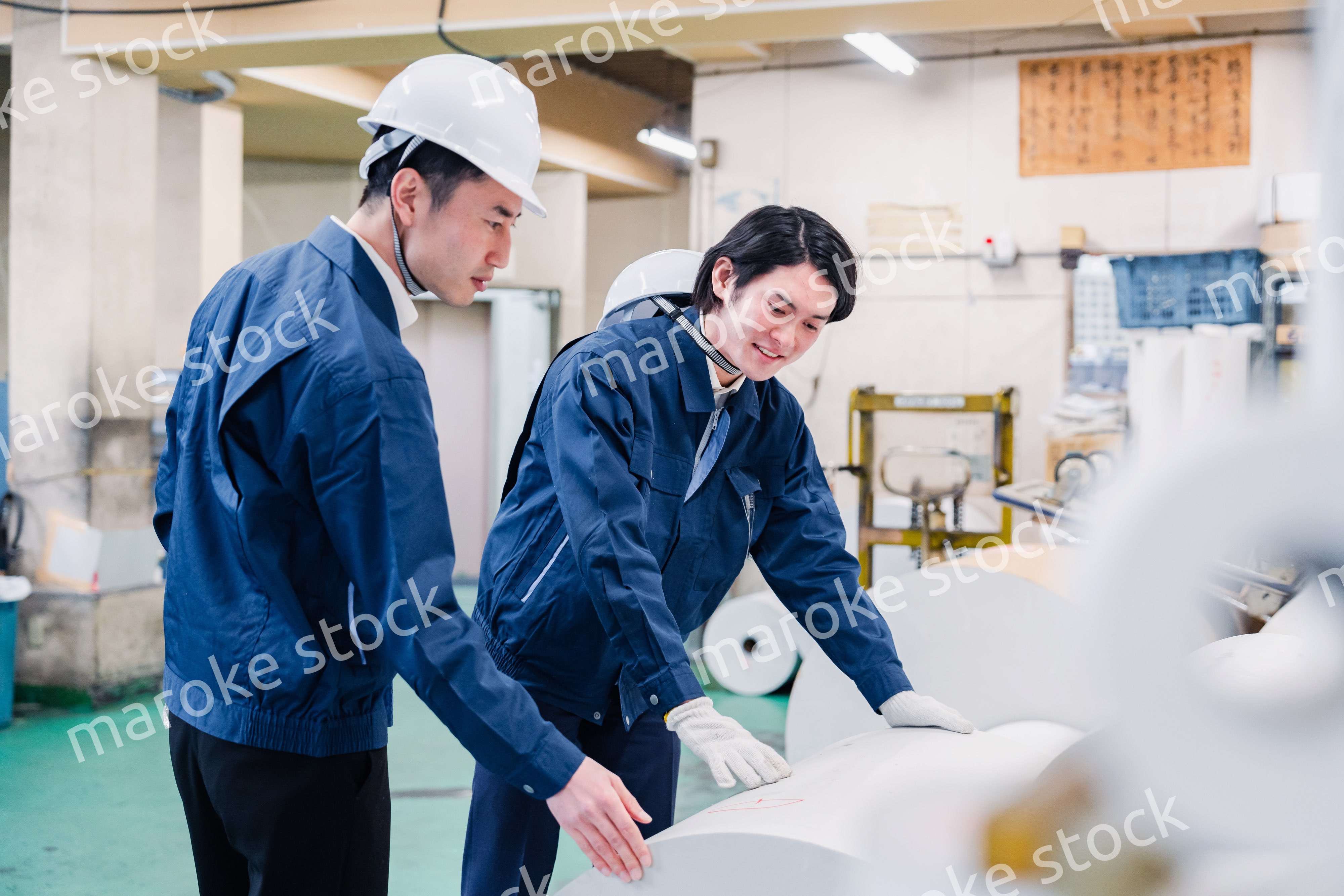 印刷工場でロール紙の確認をする作業員