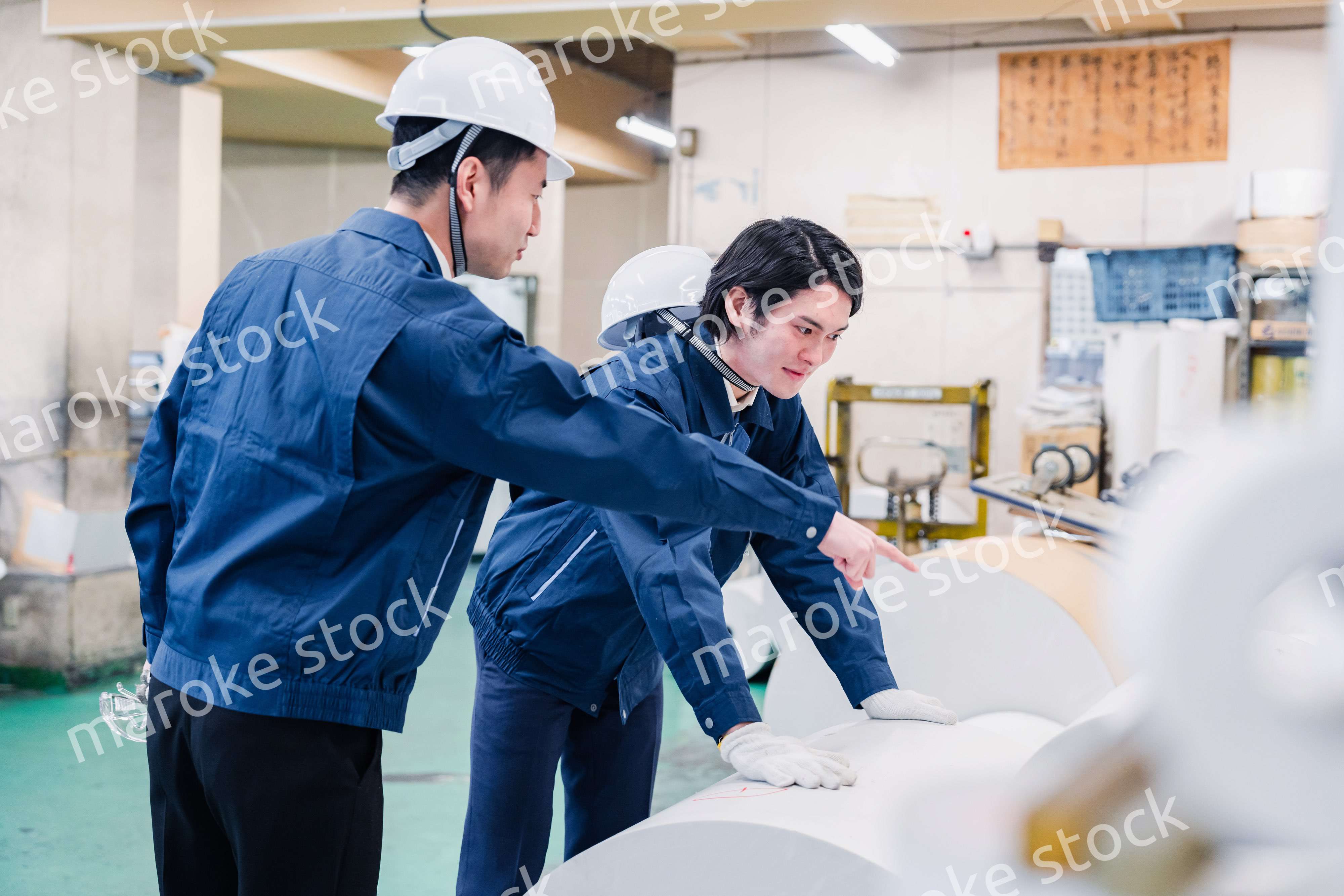 印刷工場でロール紙の確認をする作業員