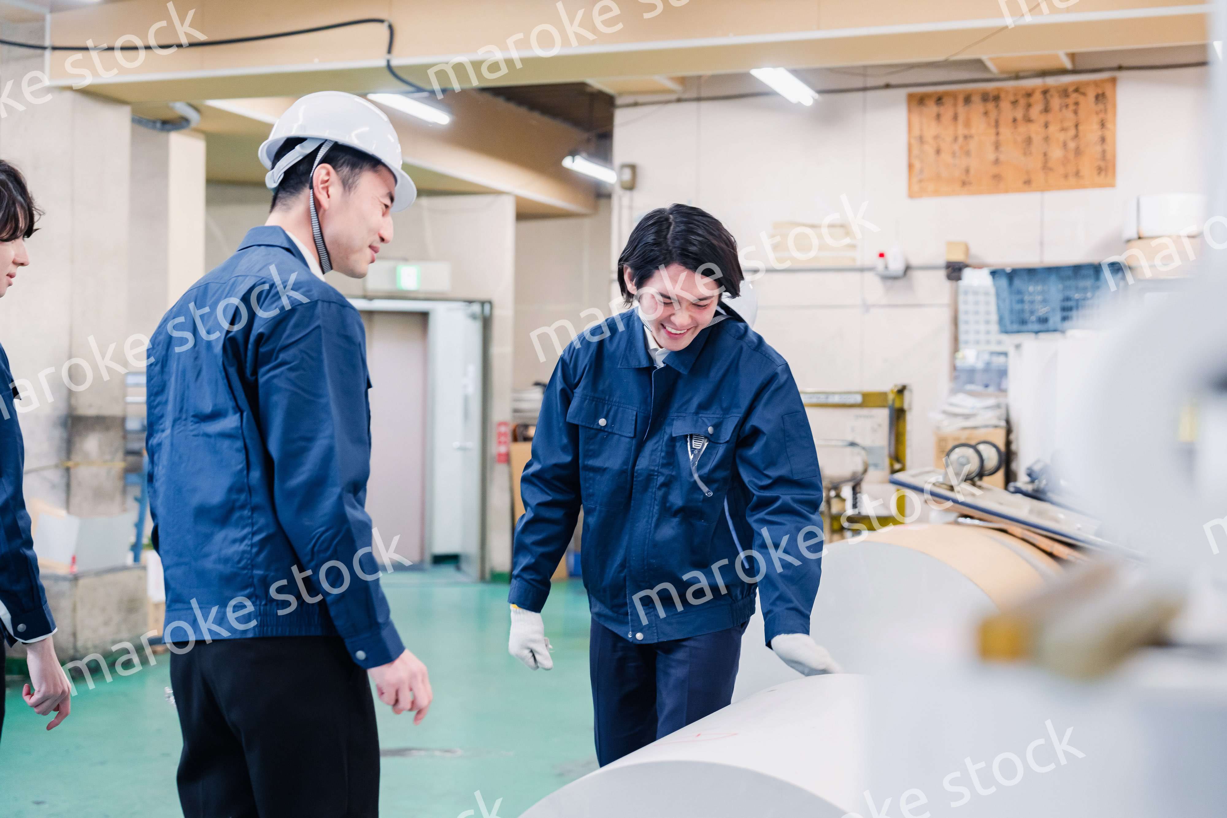 印刷工場でロール紙の確認をする作業員