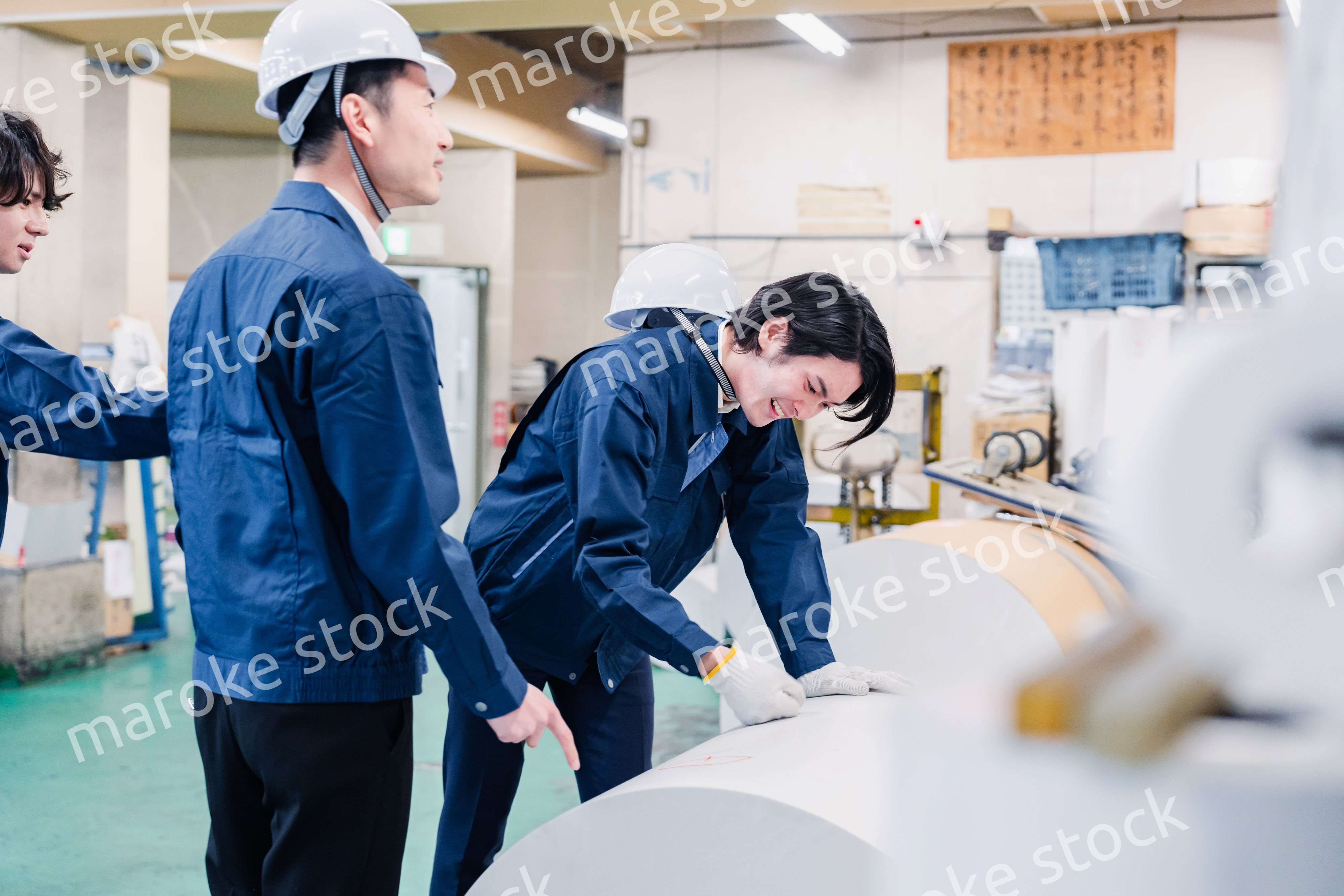 印刷工場でロール紙の確認をする作業員