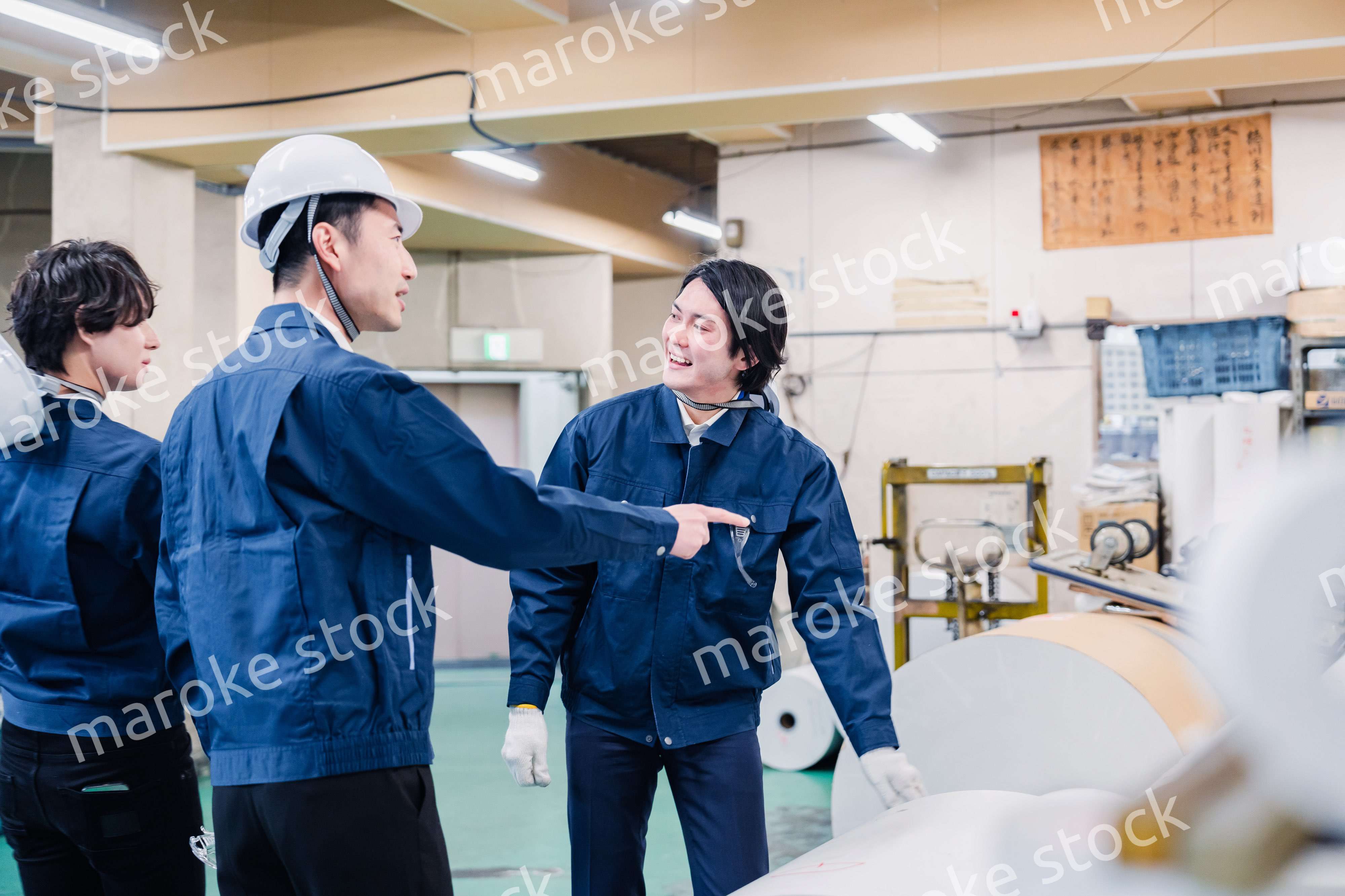 印刷工場でロール紙の確認をする作業員