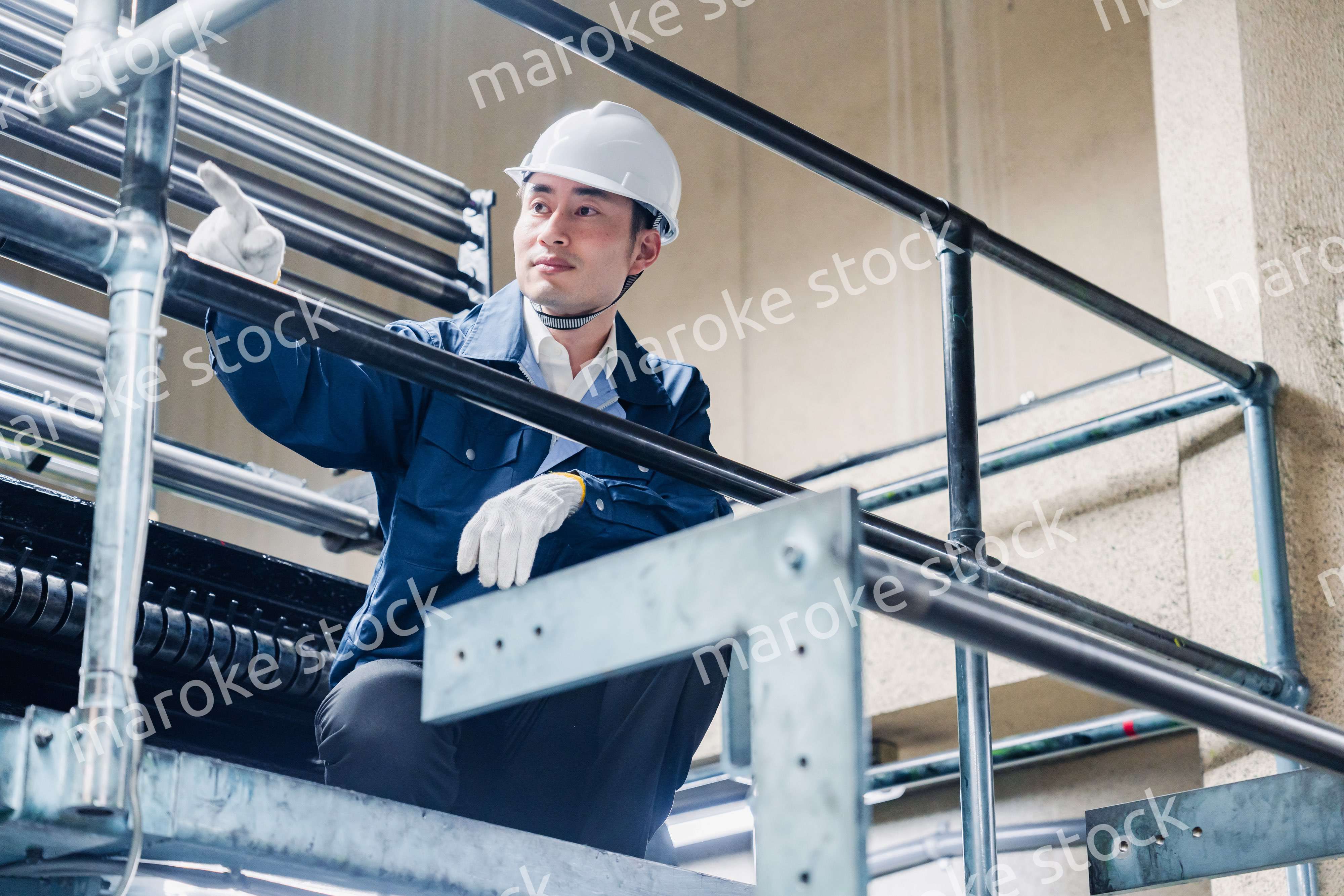 足場で高所作業をする男性作業員