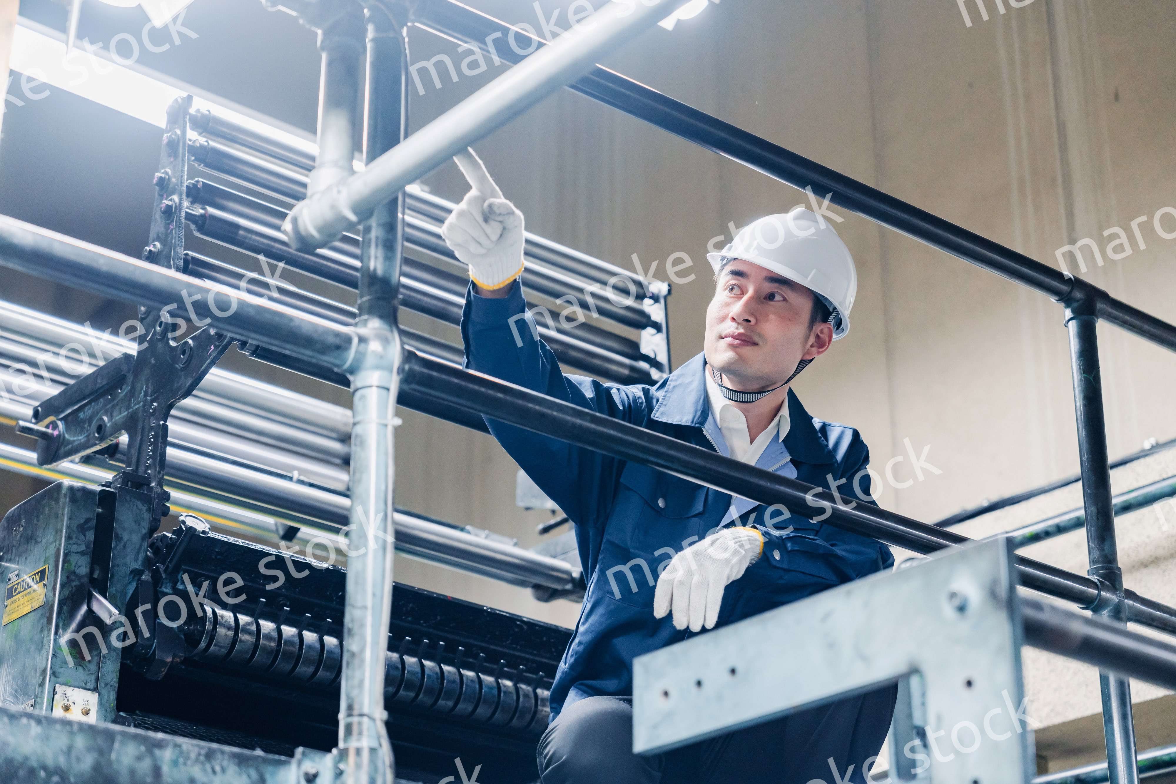 足場で高所作業をする男性作業員