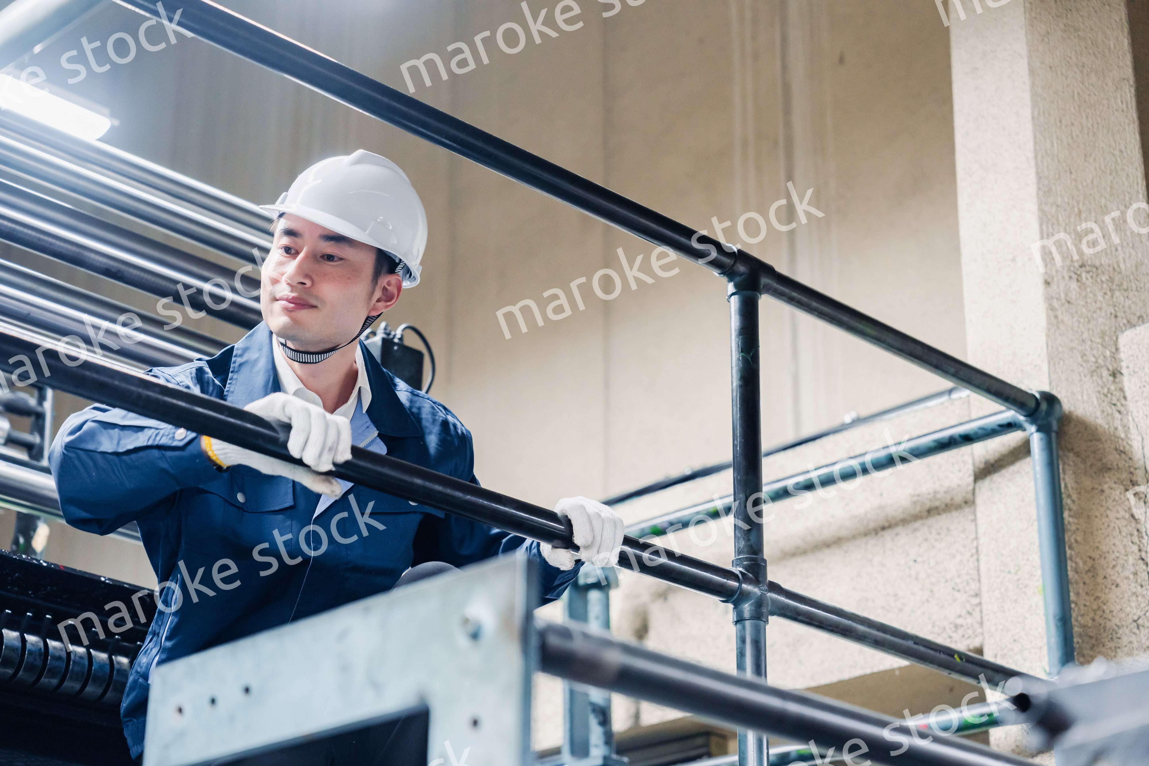 足場で高所作業をする男性作業員
