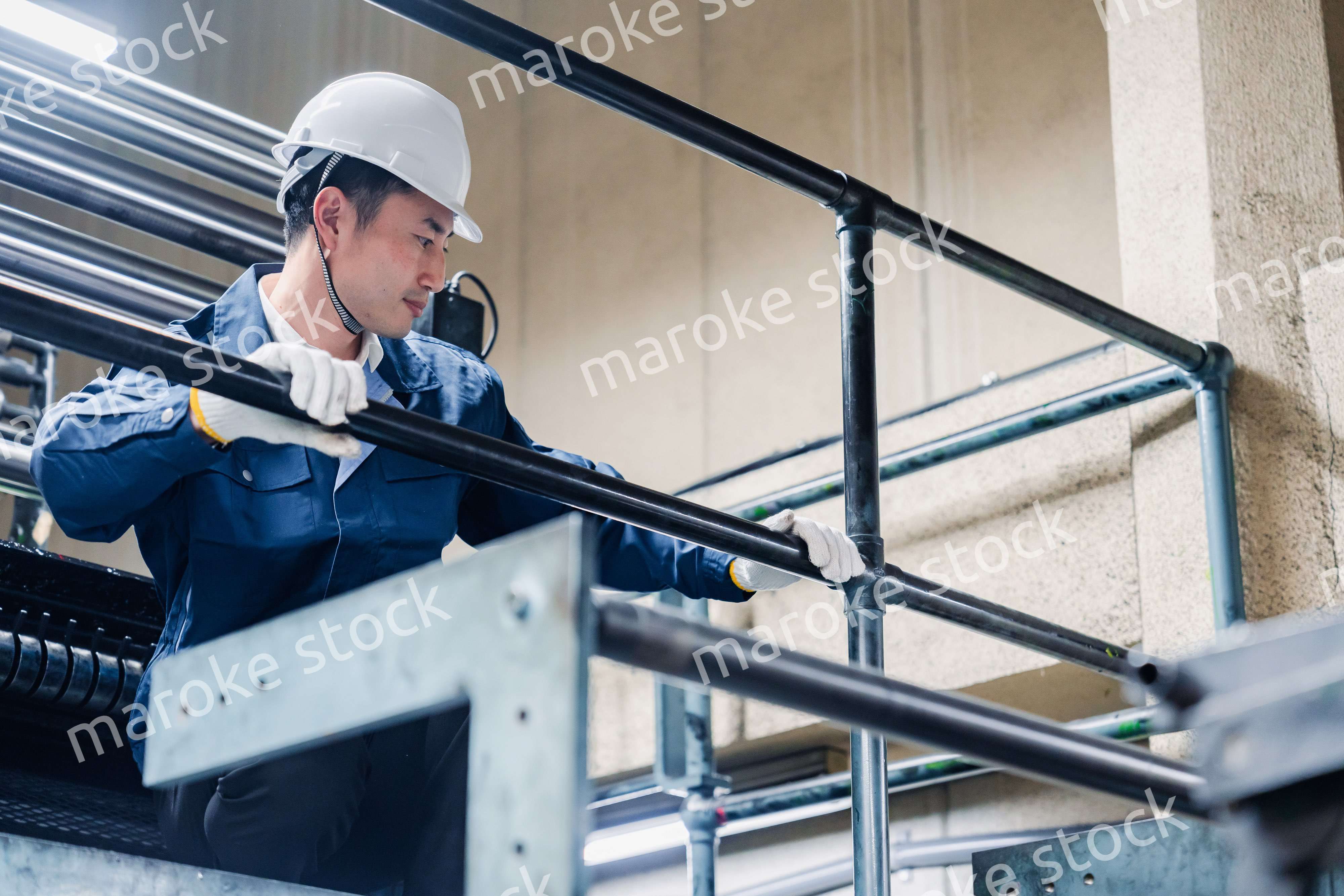 足場で高所作業をする男性作業員