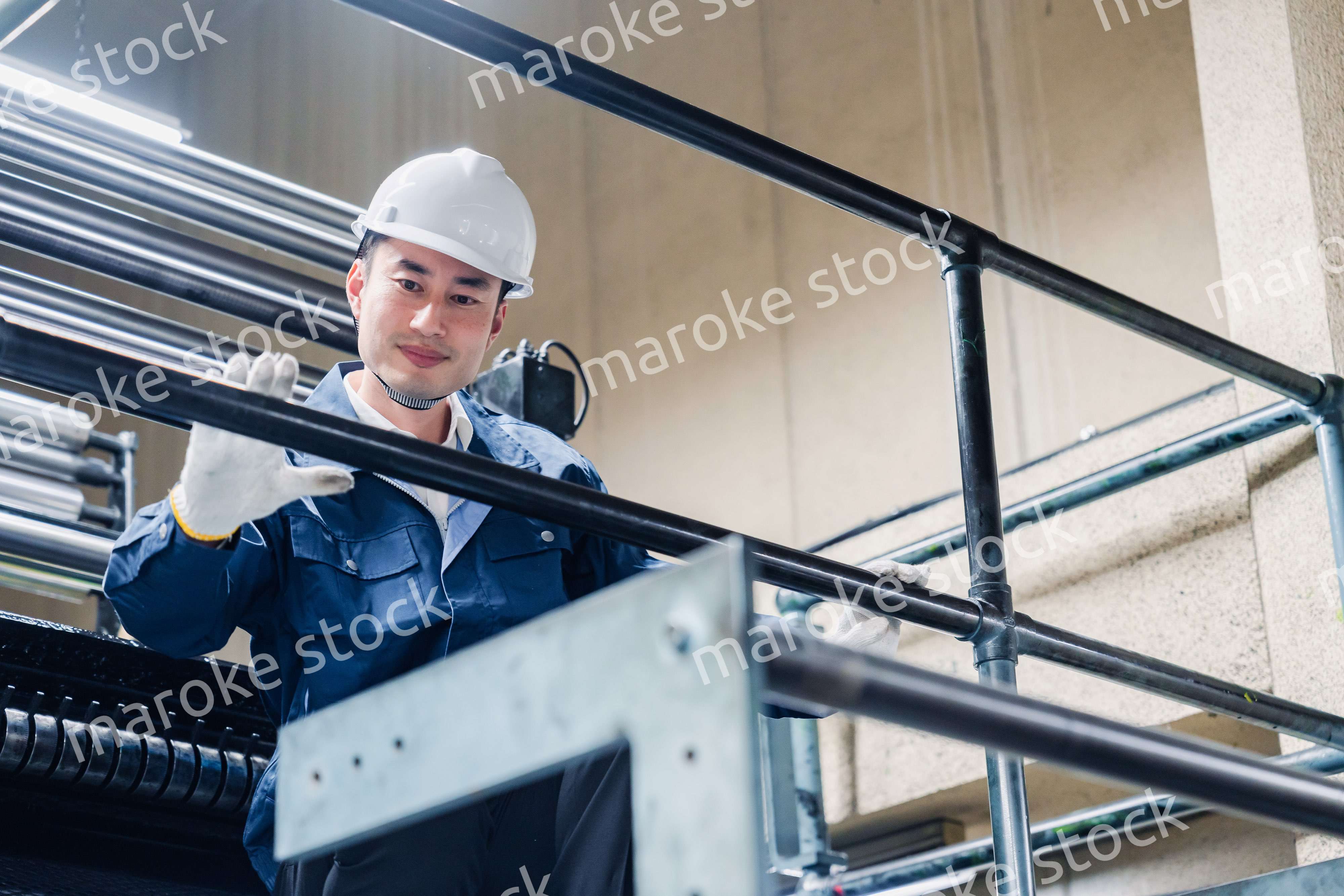 足場で高所作業をする男性作業員