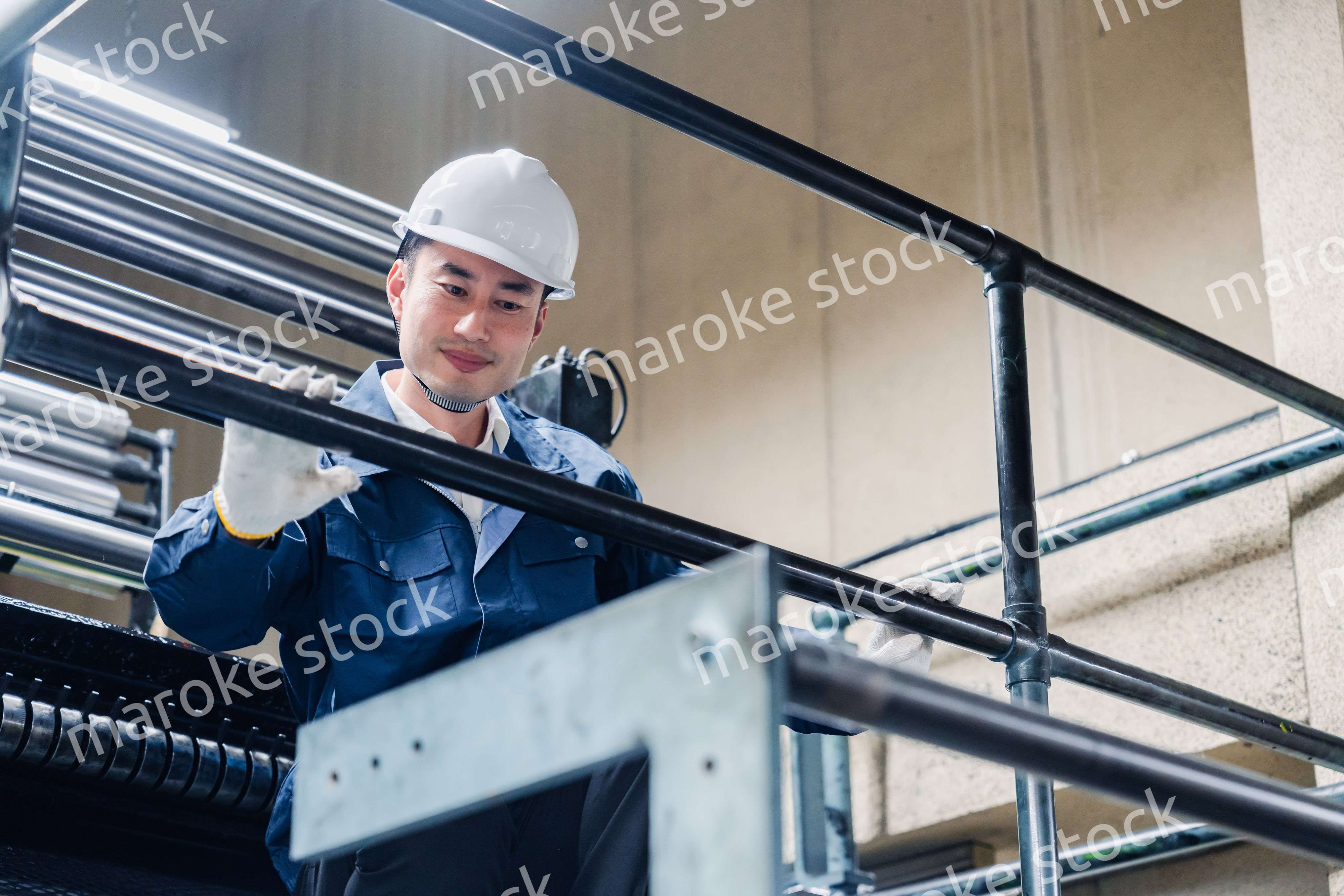 足場で高所作業をする男性作業員