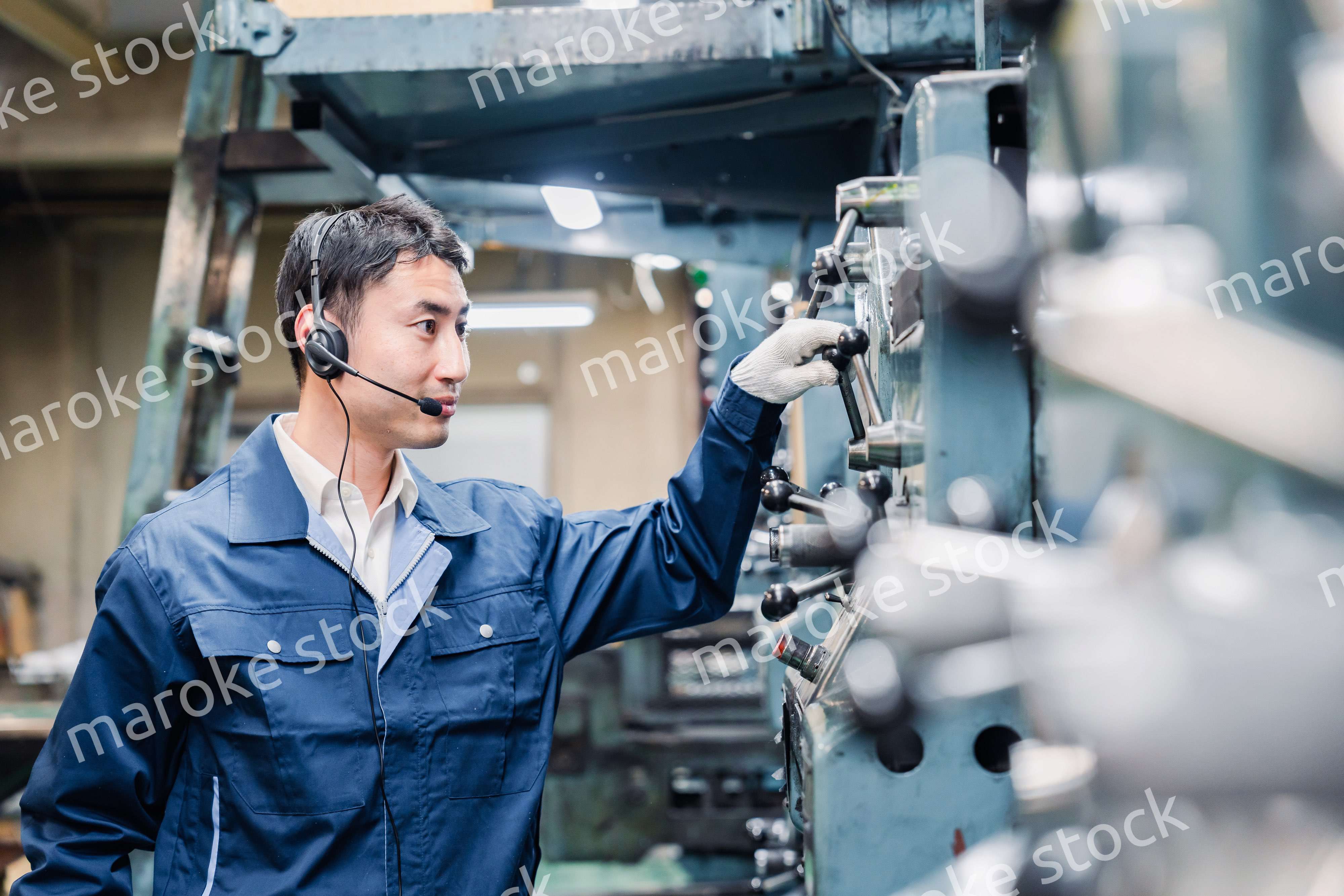 ヘッドセットをつけて重機を操作する男性作業員