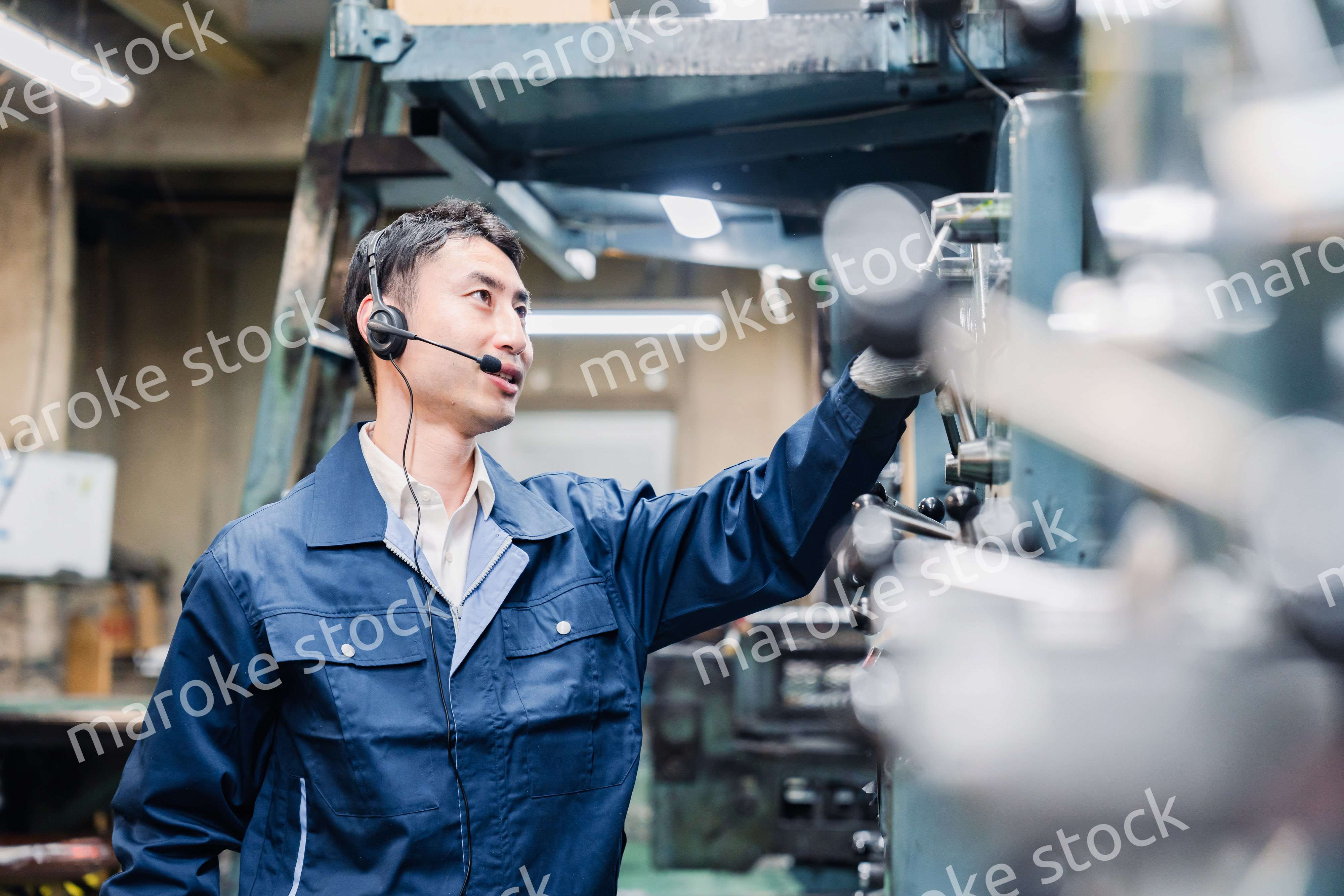 ヘッドセットをつけて重機を操作する男性作業員