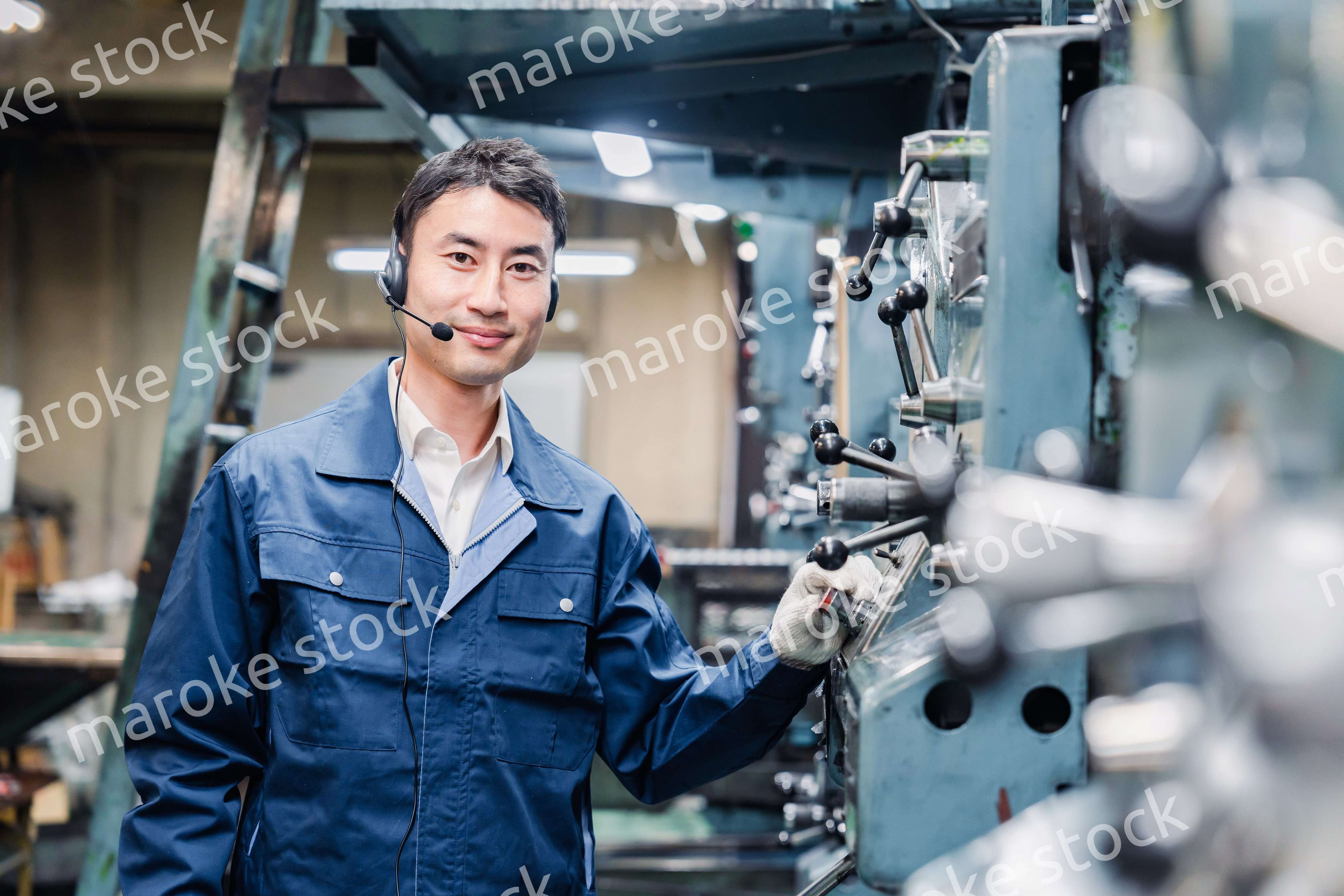 ヘッドセットをつけて重機を操作する男性作業員