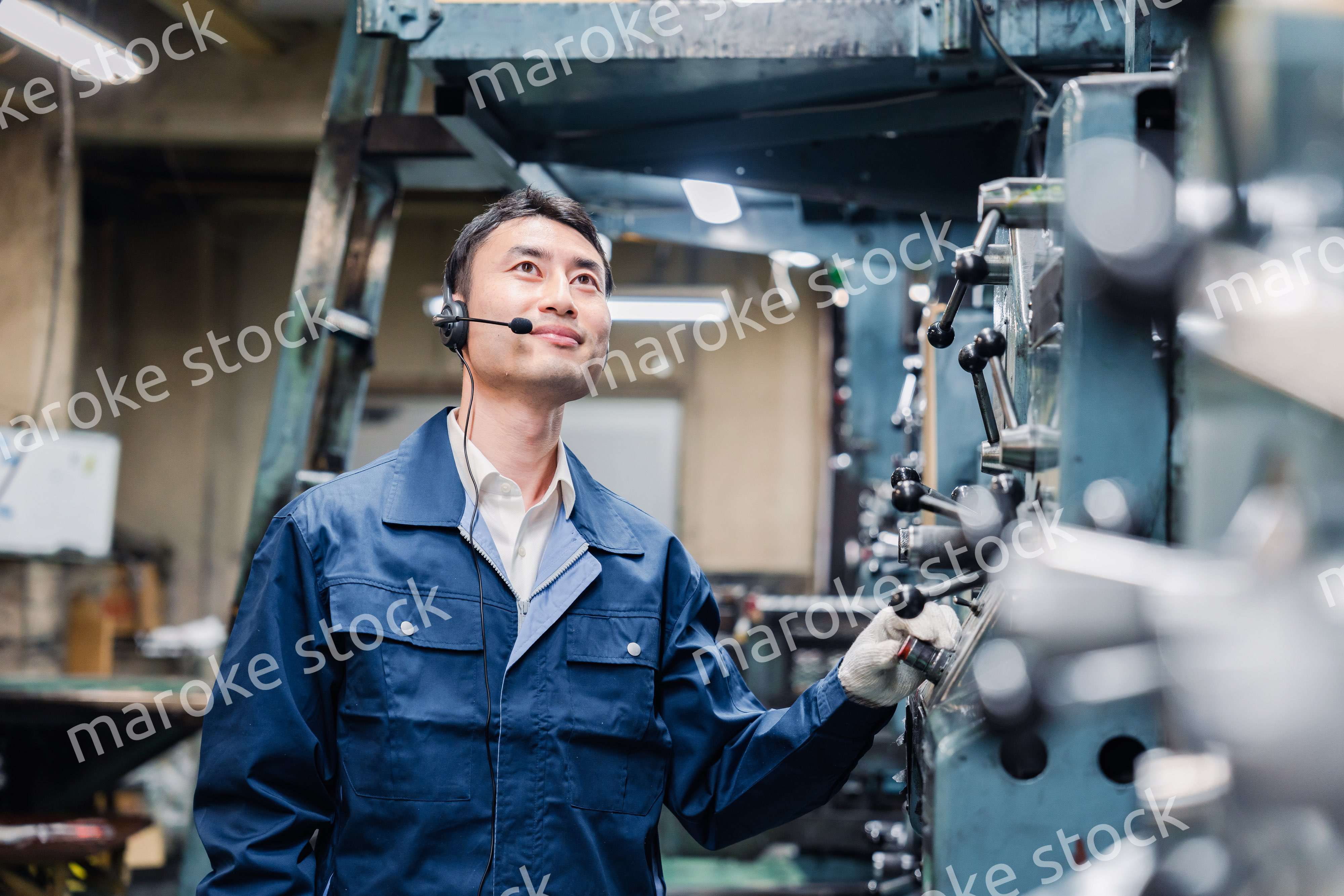 ヘッドセットをつけて重機を操作する男性作業員