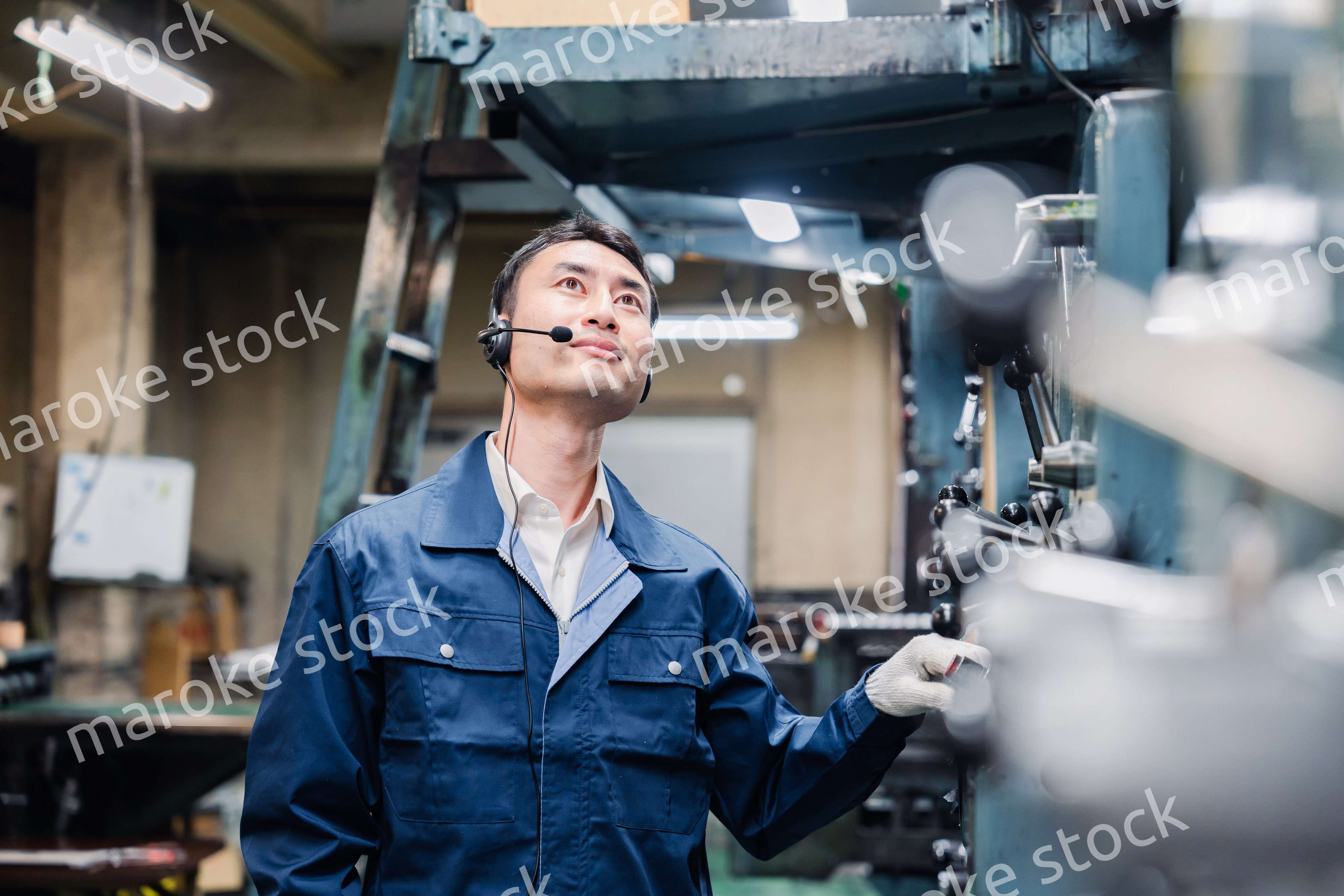 ヘッドセットをつけて重機を操作する男性作業員