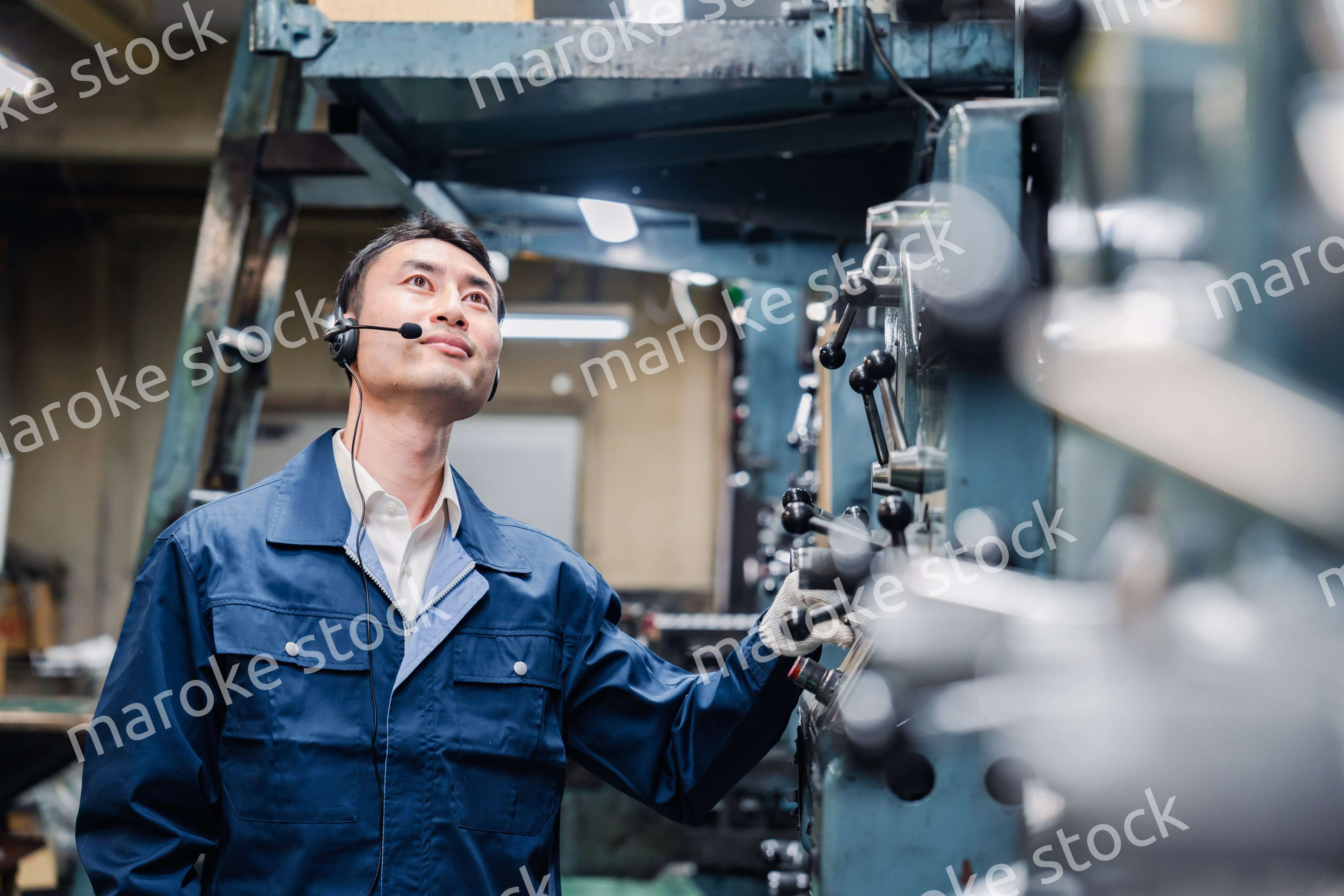 ヘッドセットをつけて重機を操作する男性作業員