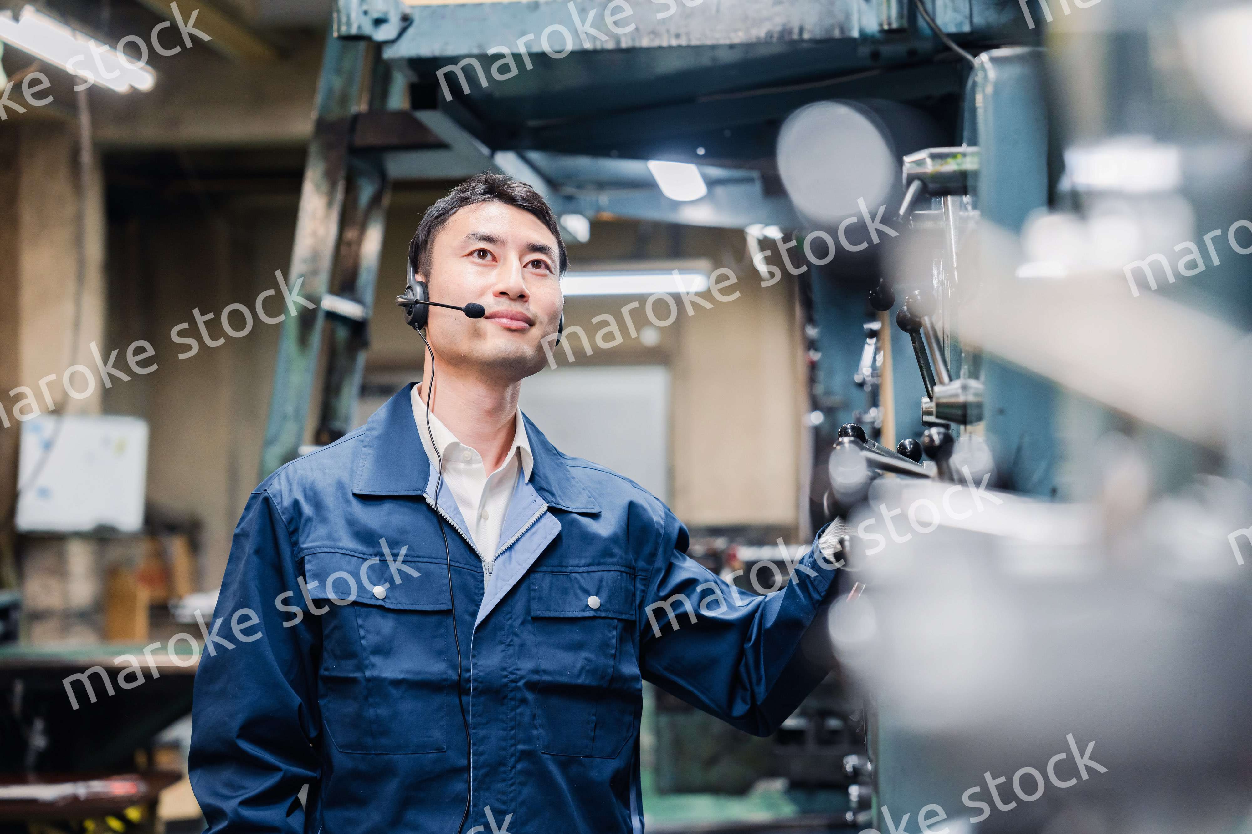 ヘッドセットをつけて重機を操作する男性作業員