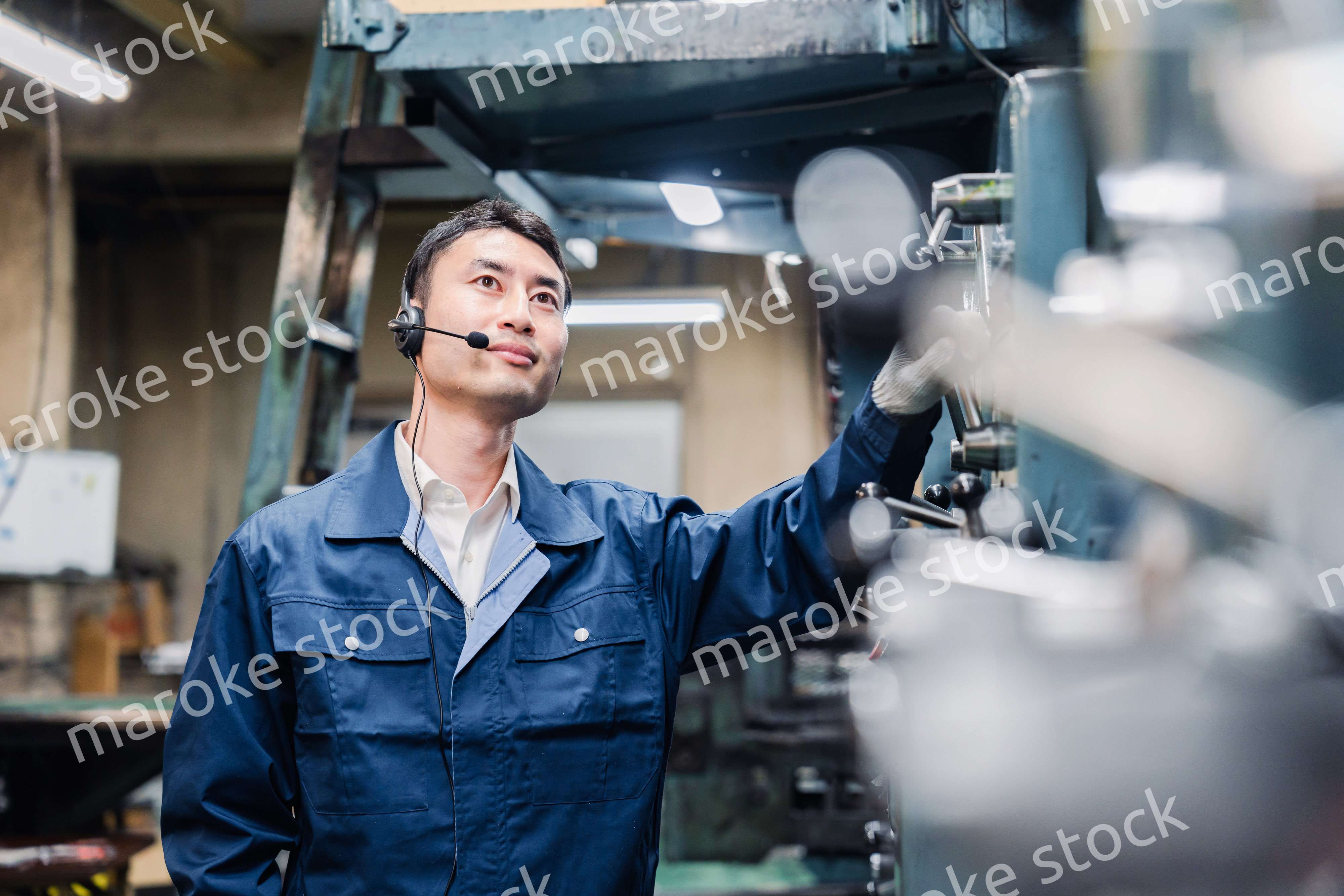 ヘッドセットをつけて重機を操作する男性作業員