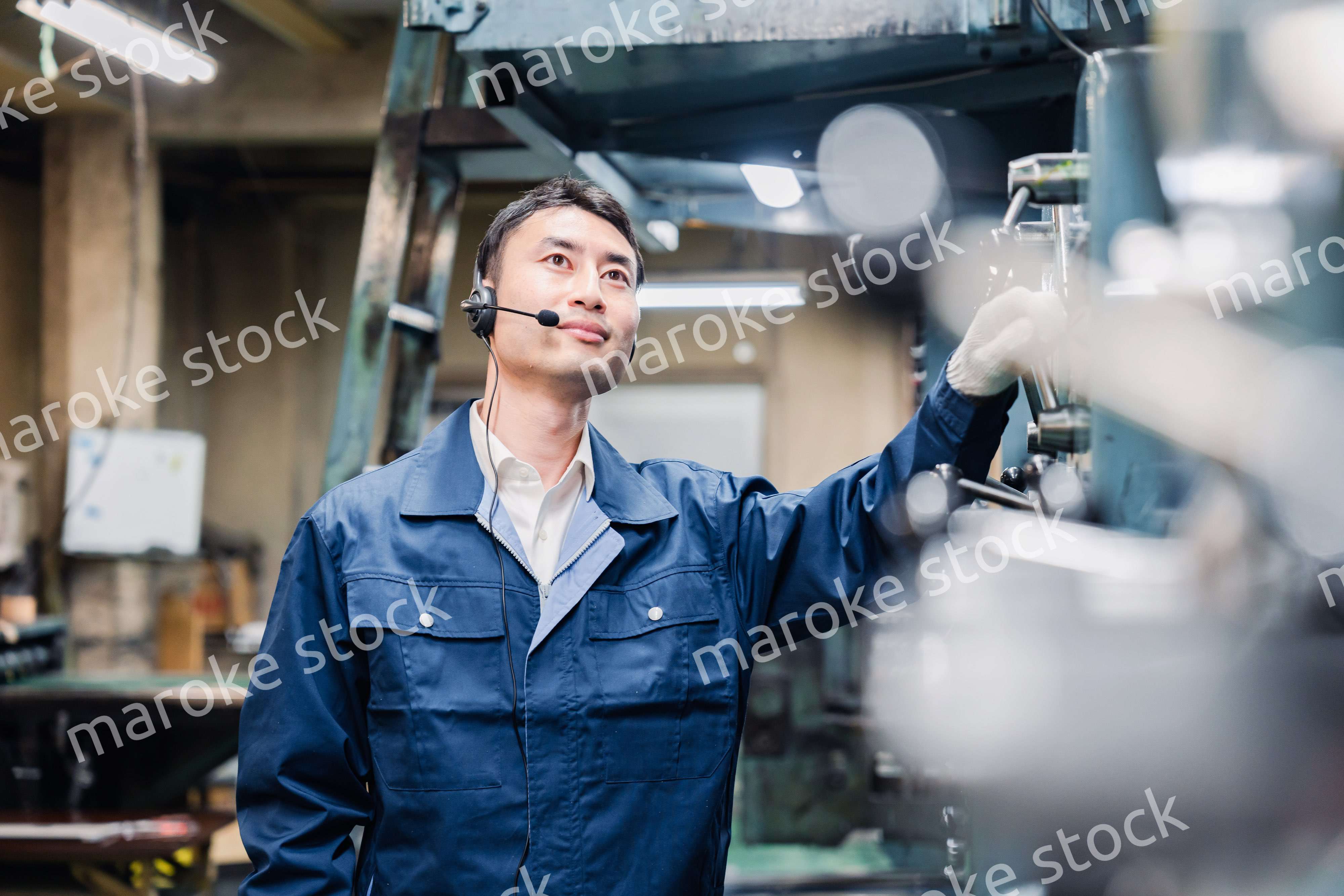 ヘッドセットをつけて重機を操作する男性作業員