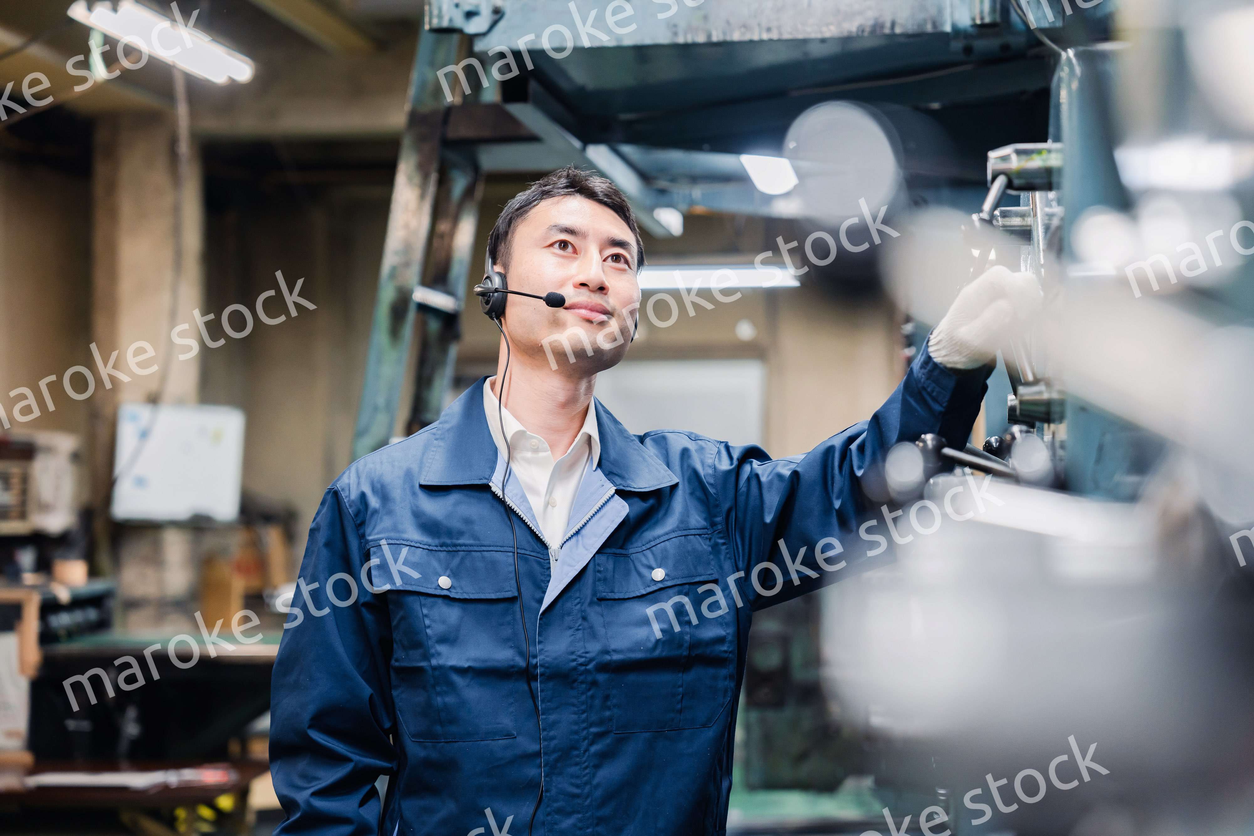 ヘッドセットをつけて重機を操作する男性作業員