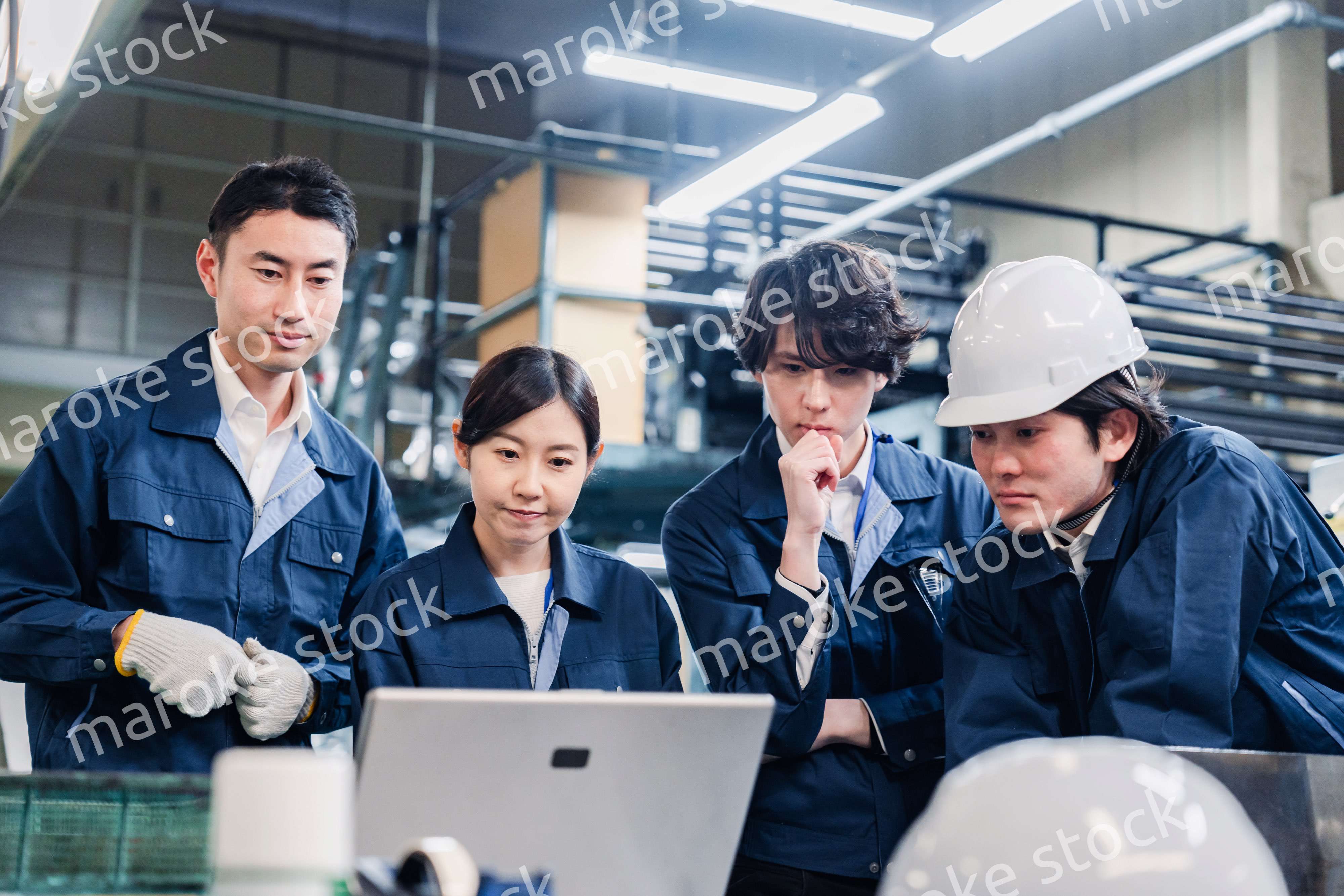 パソコンを見ながら議論をする工場スタッフ