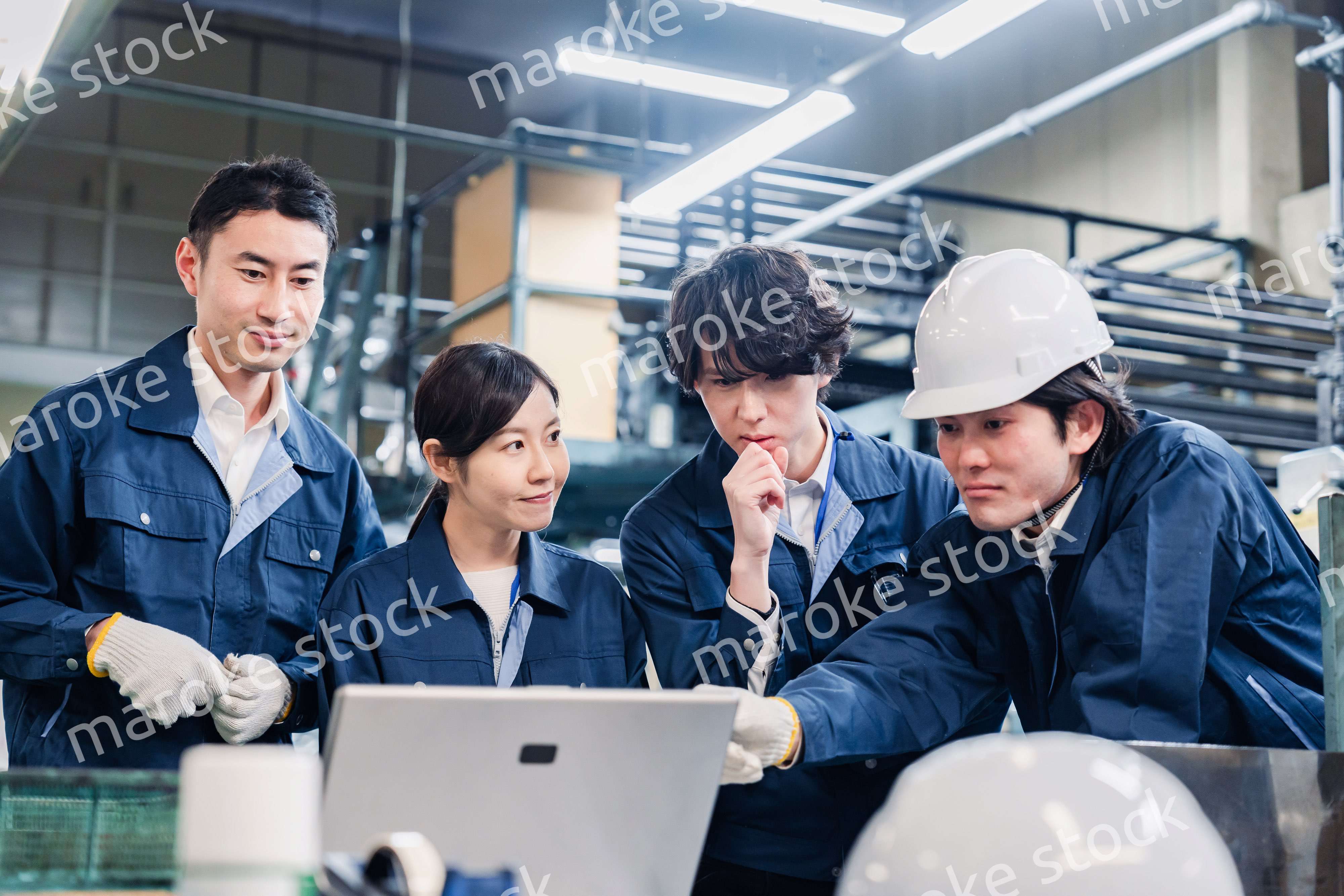 パソコンを見ながら議論をする工場スタッフ