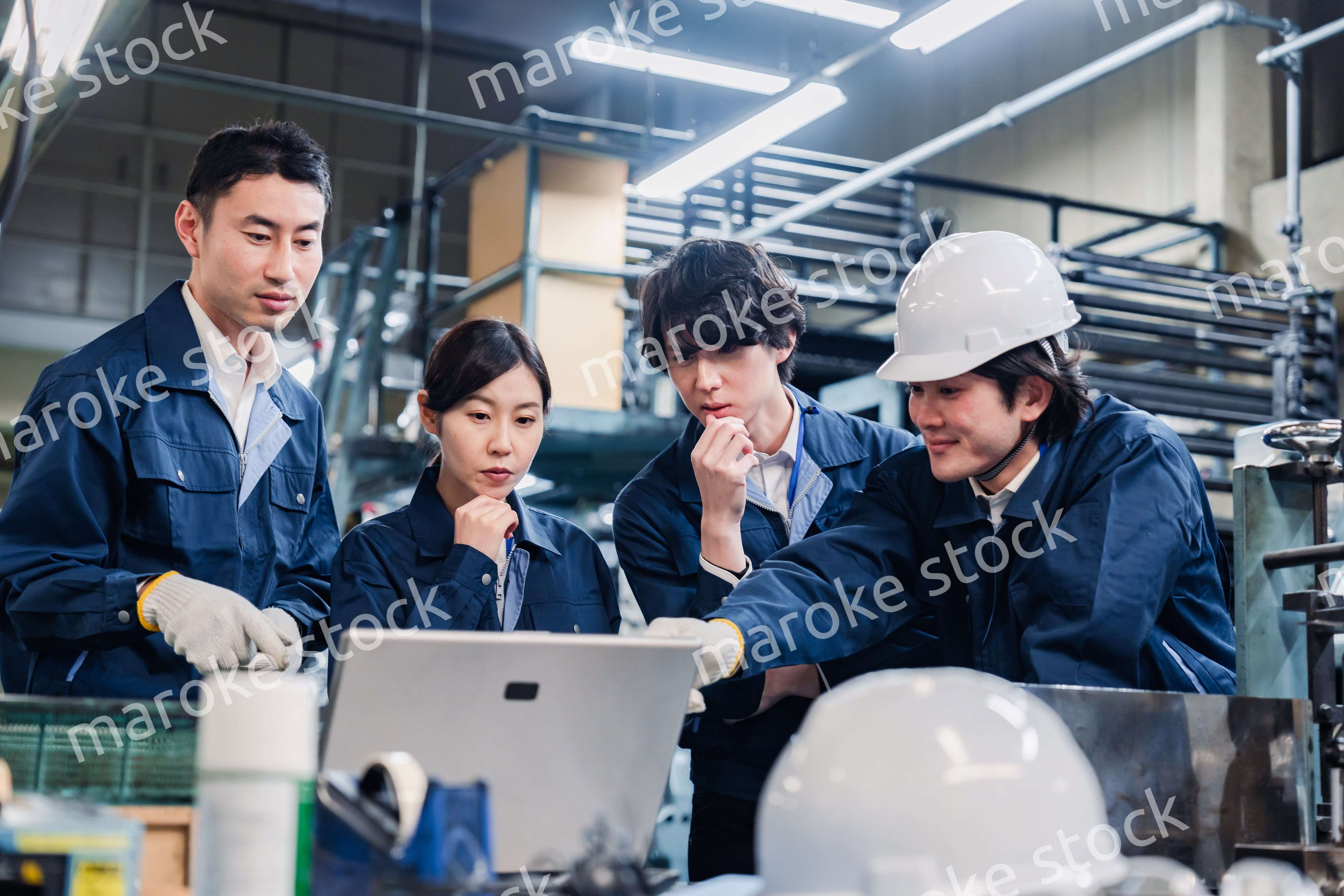 パソコンを見ながら議論をする工場スタッフ