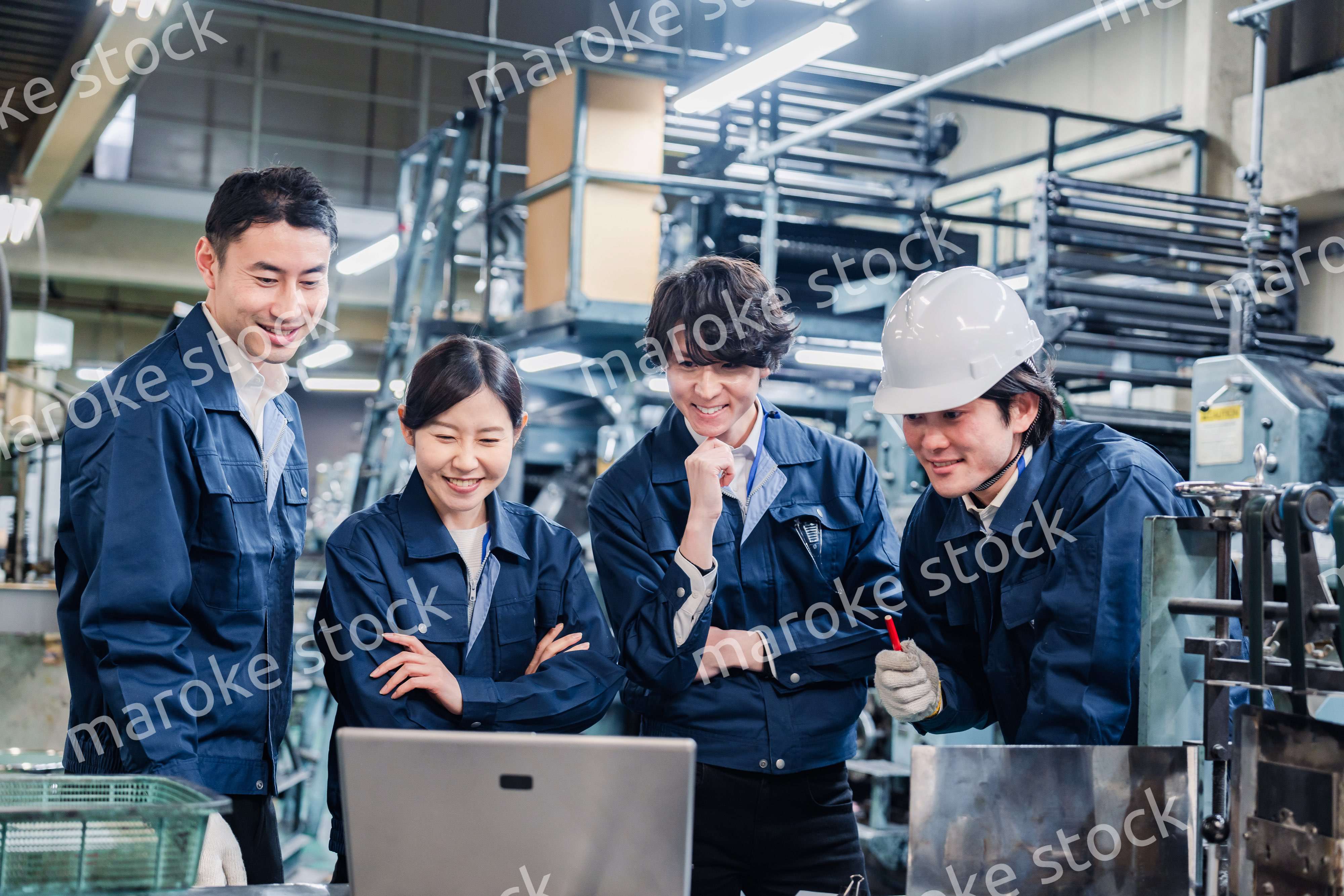パソコンを見ながら議論をする工場スタッフ