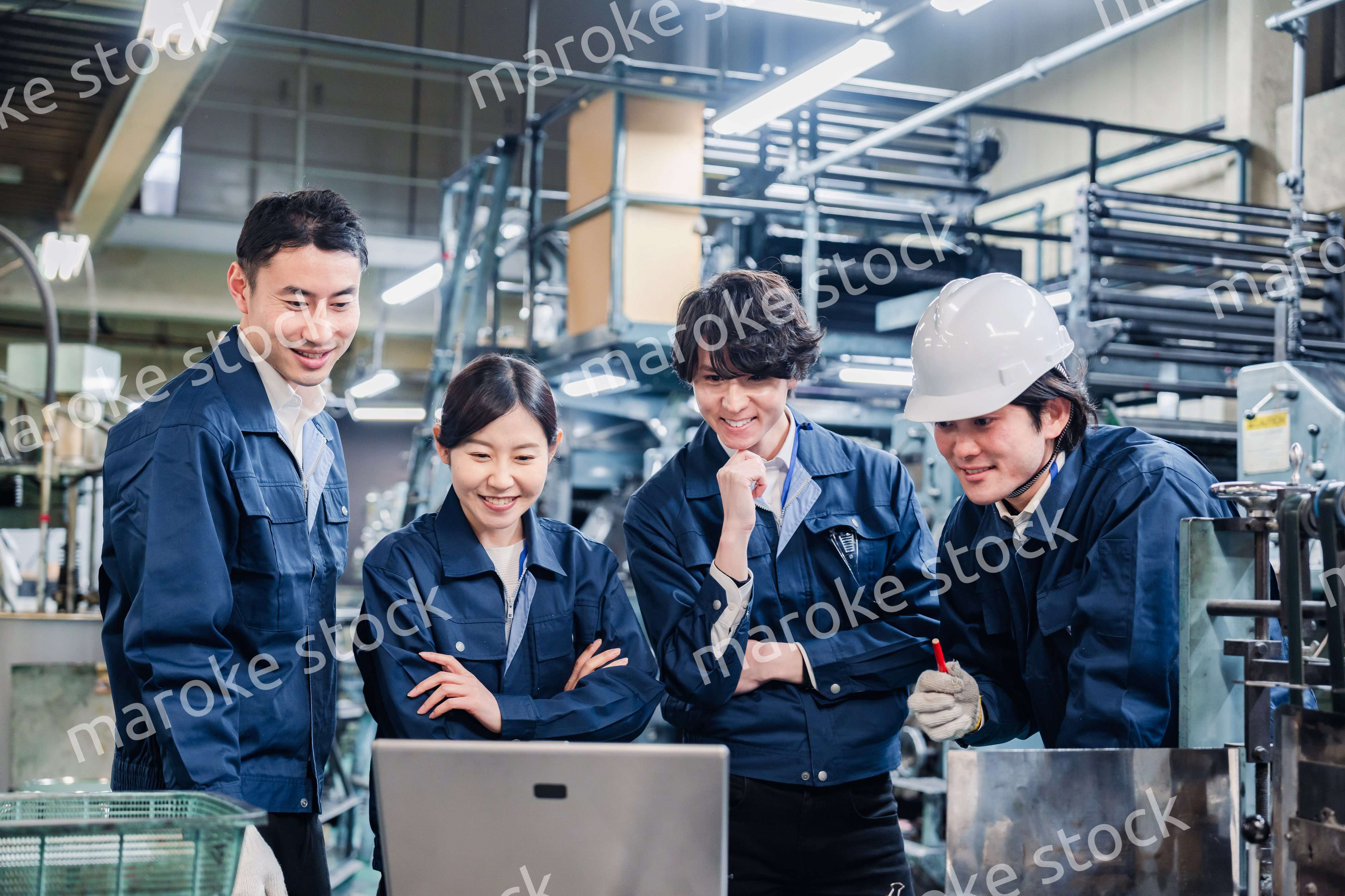 パソコンを見ながら議論をする工場スタッフ