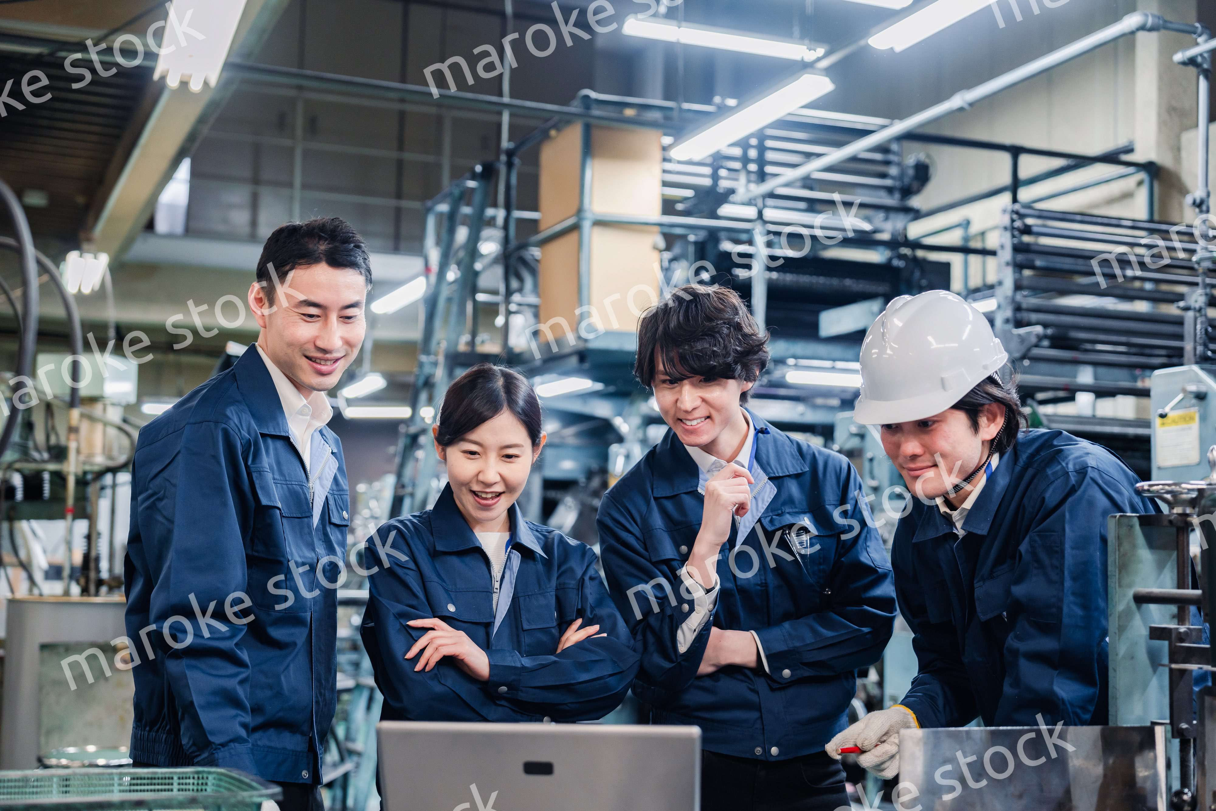 パソコンを見ながら議論をする工場スタッフ