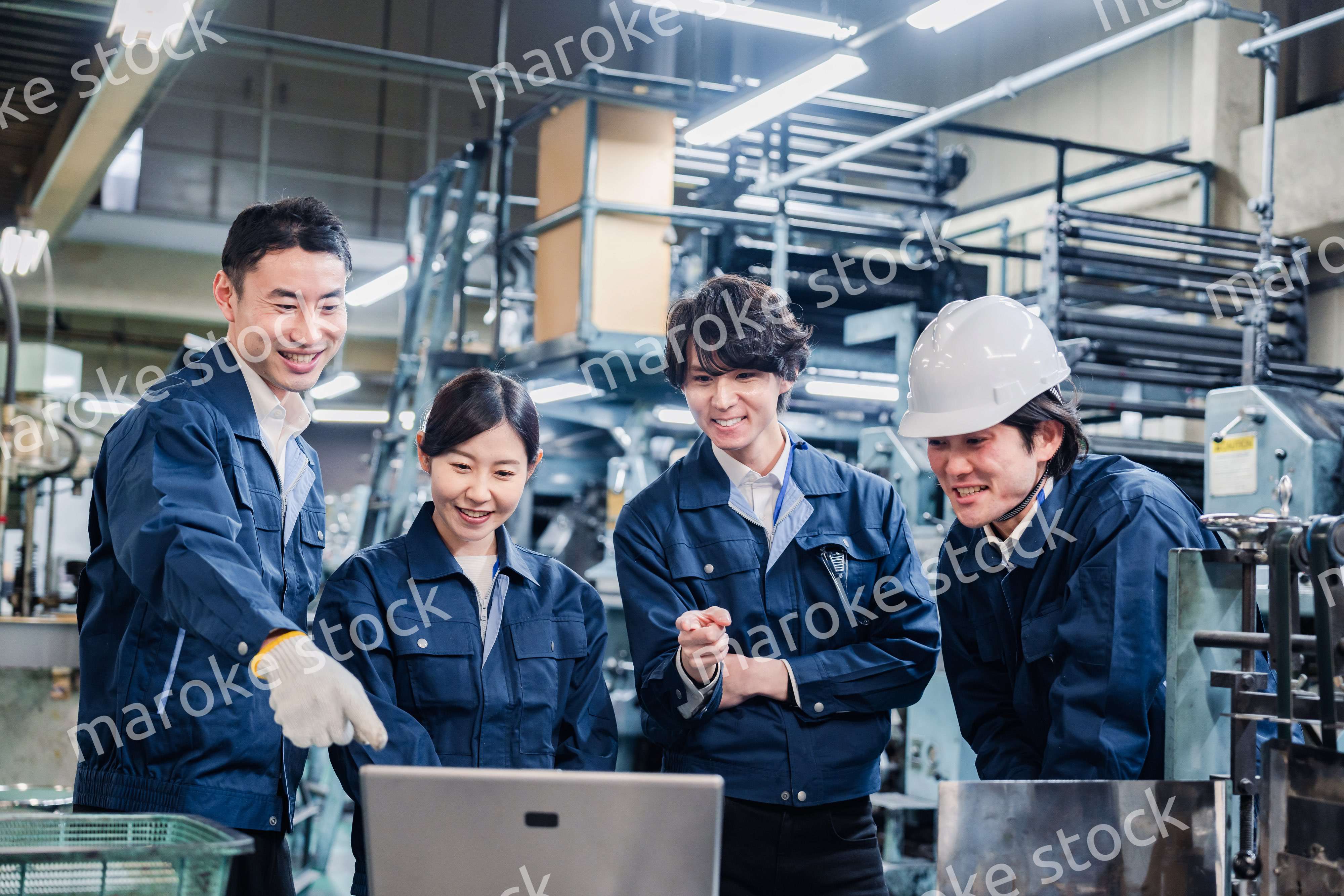 パソコンを見ながら議論をする工場スタッフ