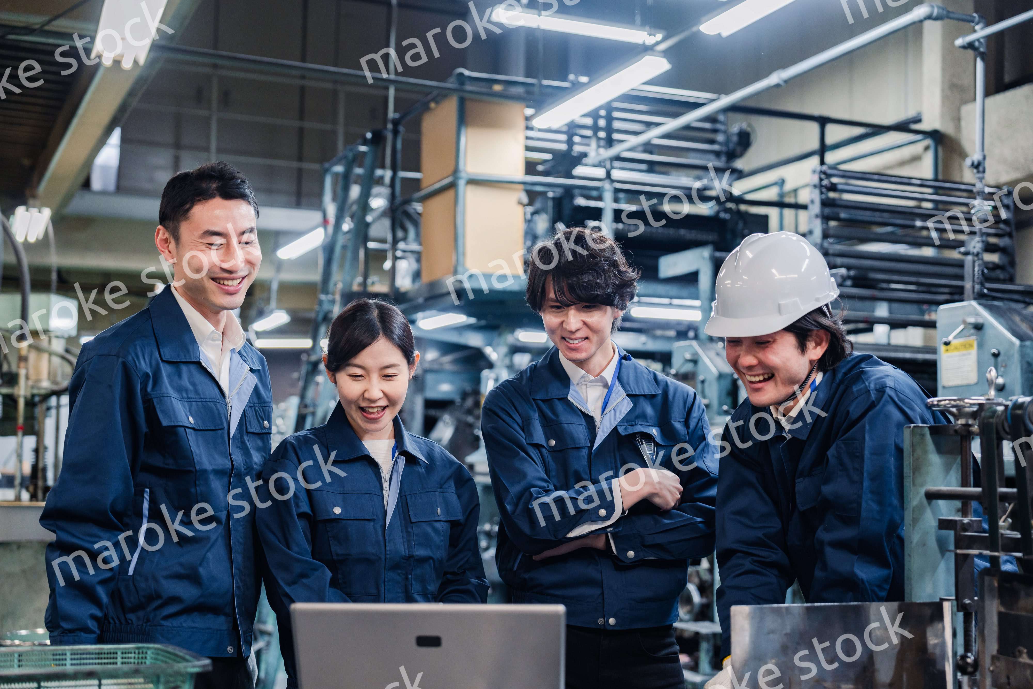 パソコンを見ながら議論をする工場スタッフ