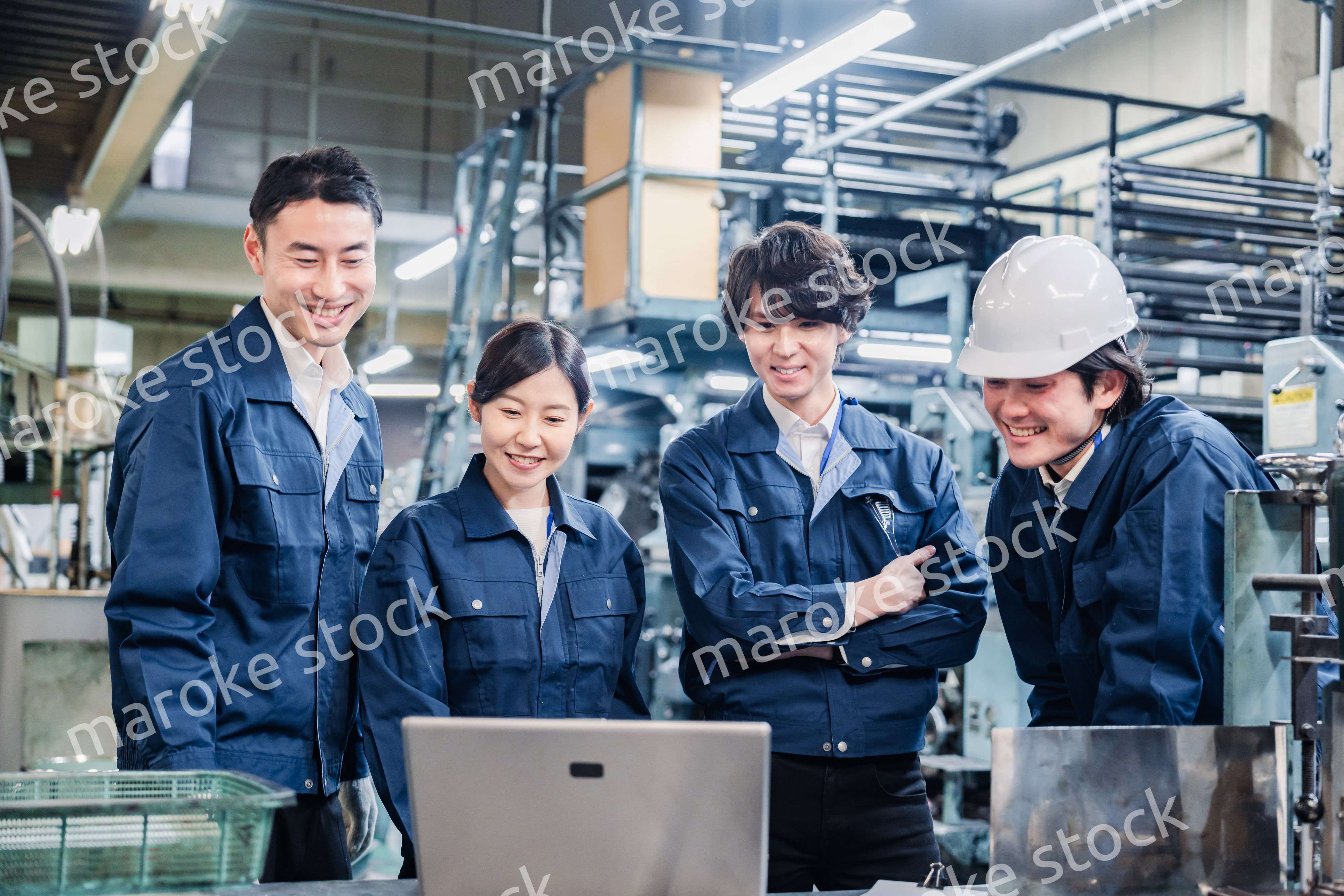 パソコンを見ながら議論をする工場スタッフ
