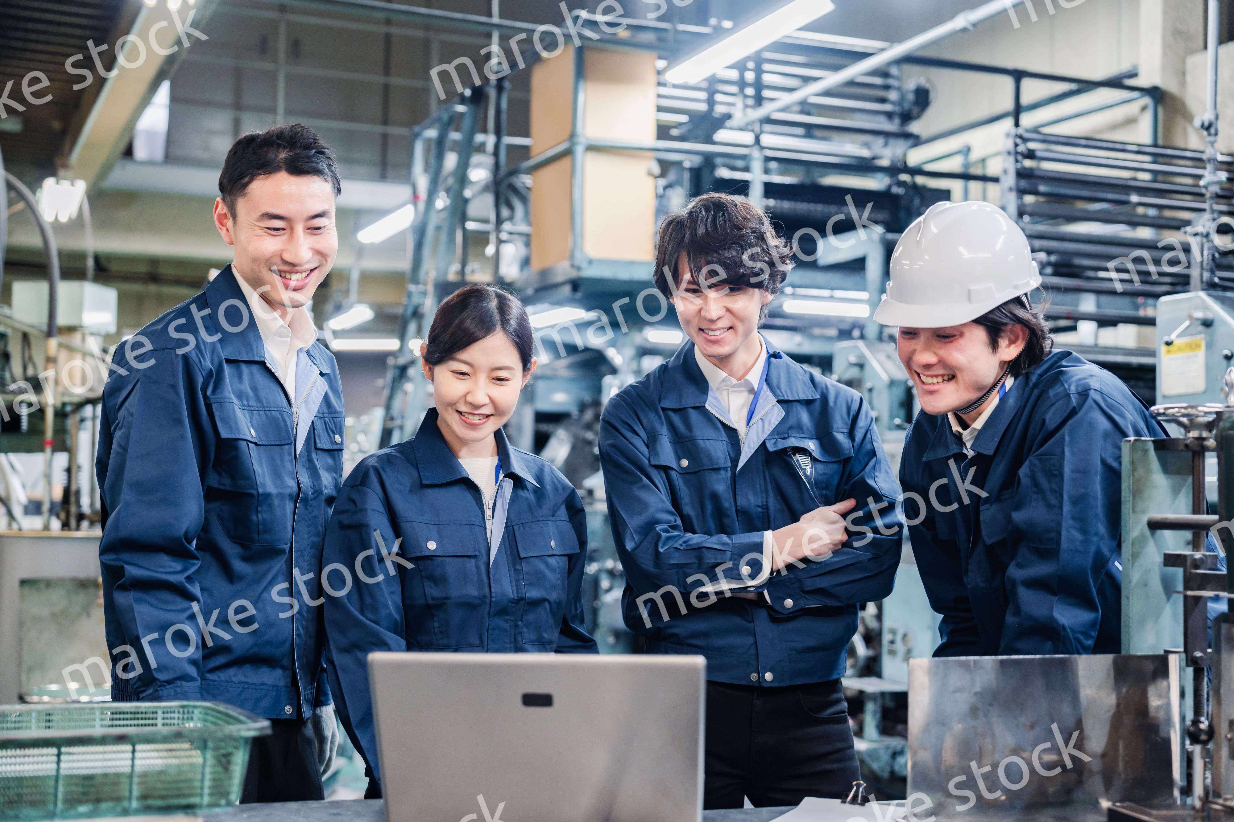 パソコンを見ながら議論をする工場スタッフ
